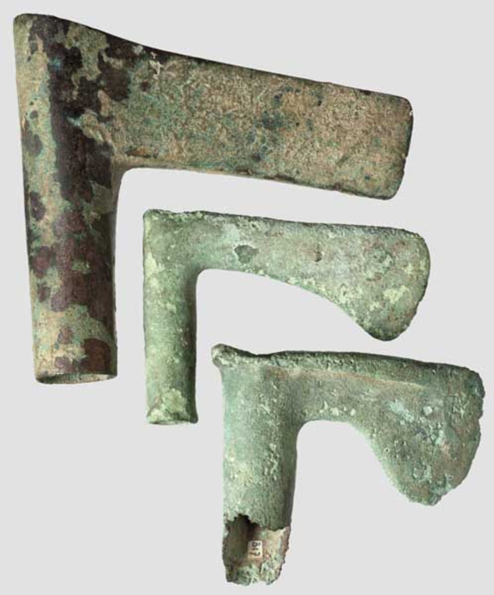 Drei Axtköpfe, Luristan um 1000 v. Chr.   Bronze mit unterschiedlicher Patina. Unterschiedliche