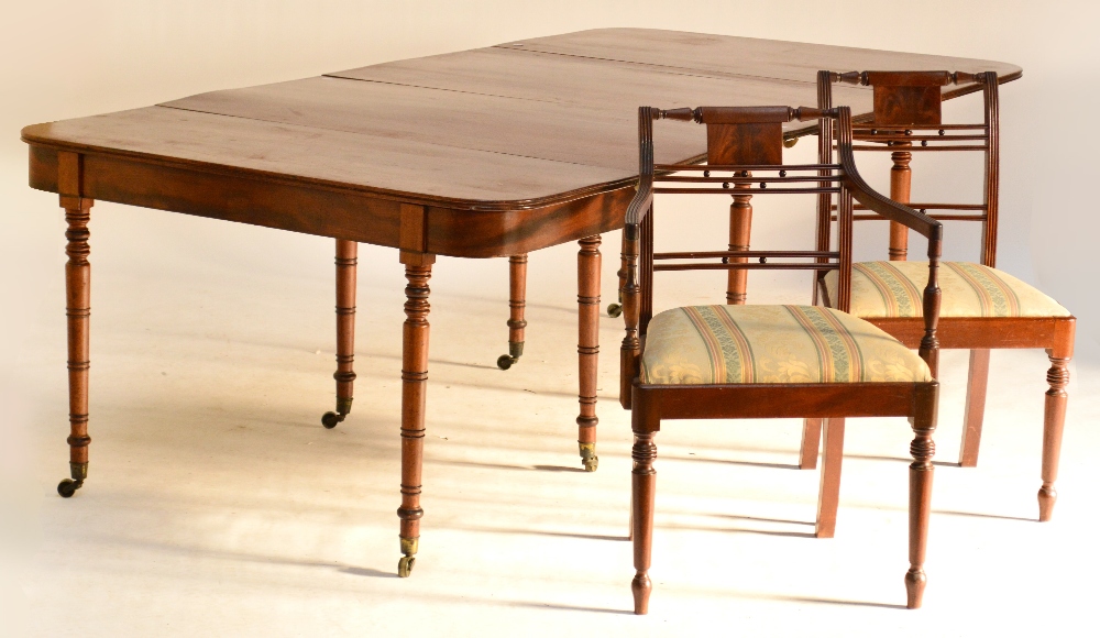 A late George III mahogany D-end dropleaf dining table with two additional leaves and raised on ring
