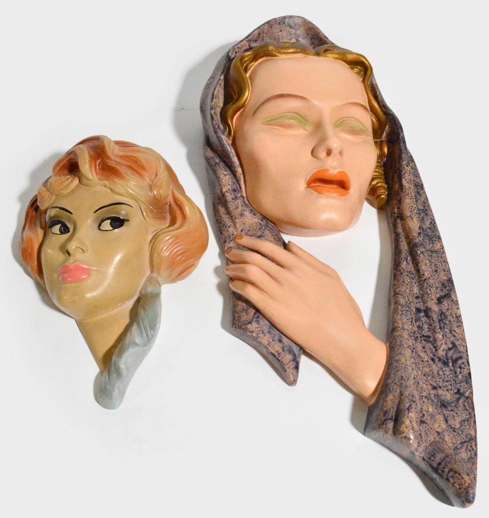 An Art Deco painted plaster wall hanging modelled as the head of a young woman with hand beneath her