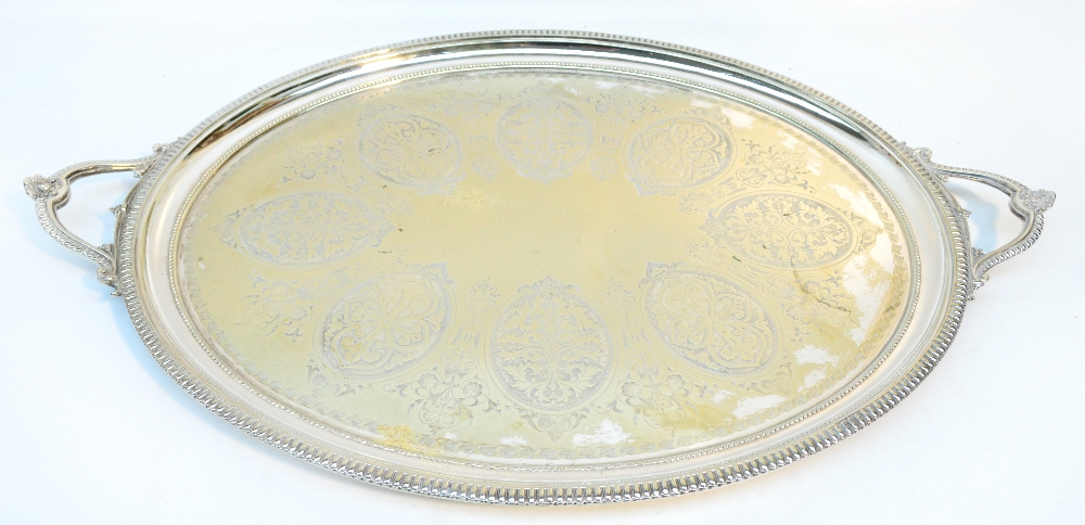 An Edwardian electroplated twin handled oval tea tray, engraved with foliate sprays within a