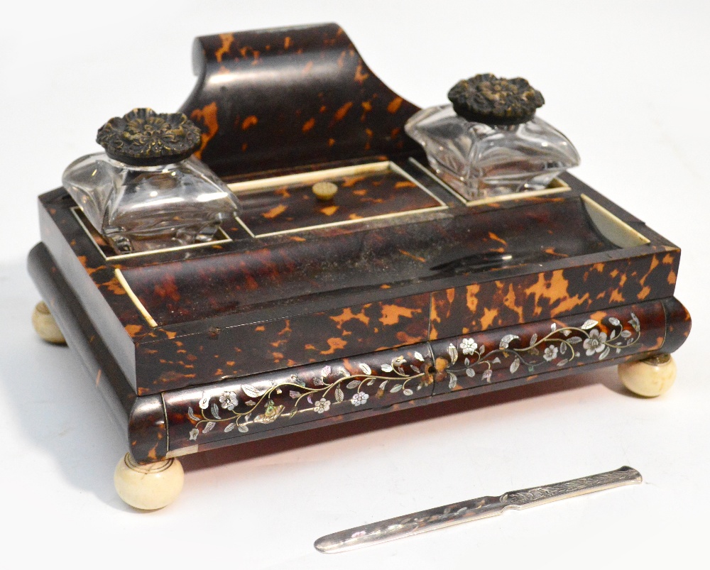 A Regency tortoiseshell inkstand with scroll back, central lidded compartment flanked by a pair of