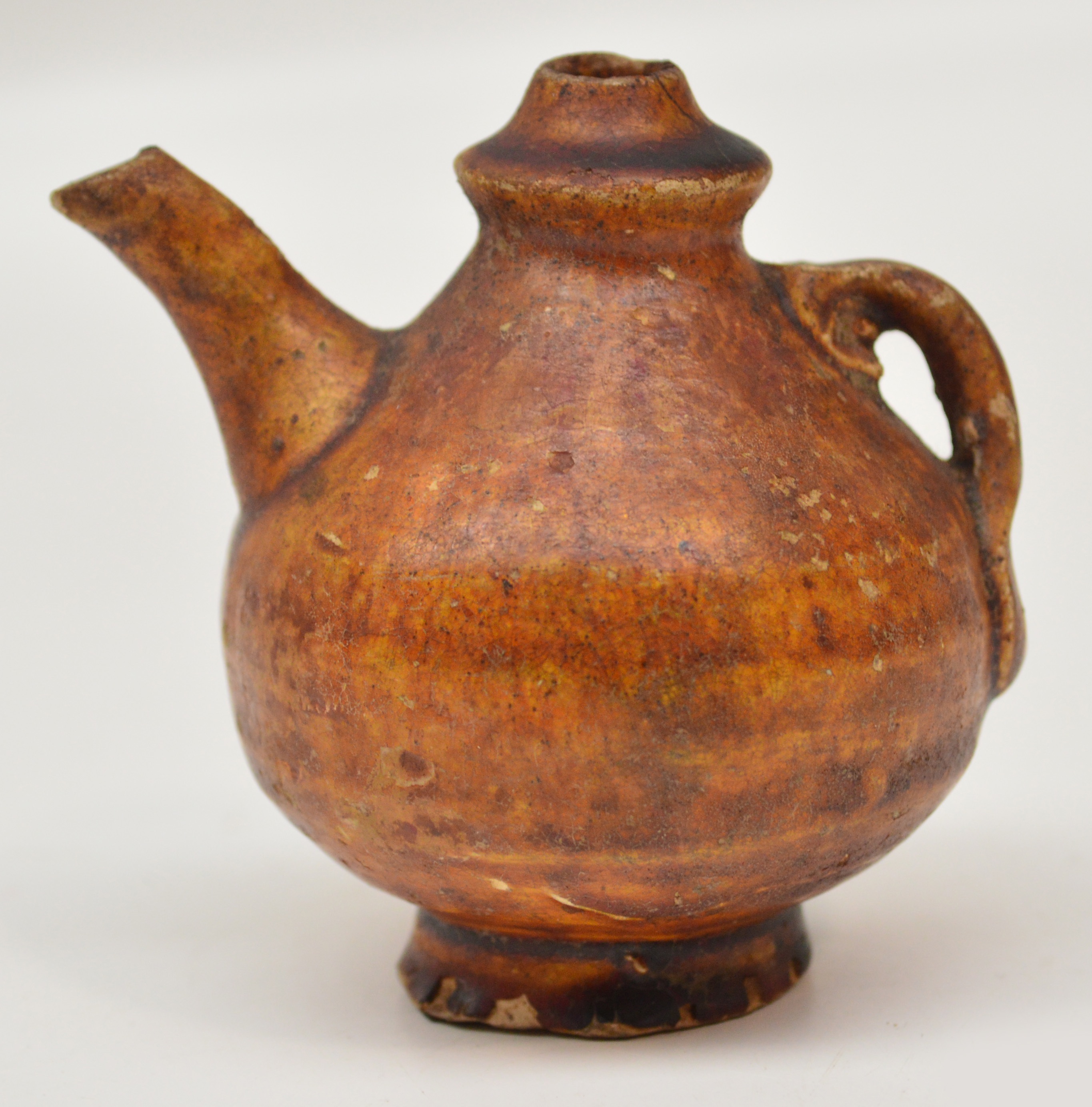 A 12th century Chinese lead glazed amber coloured water dropper with angular spout and lug handle,