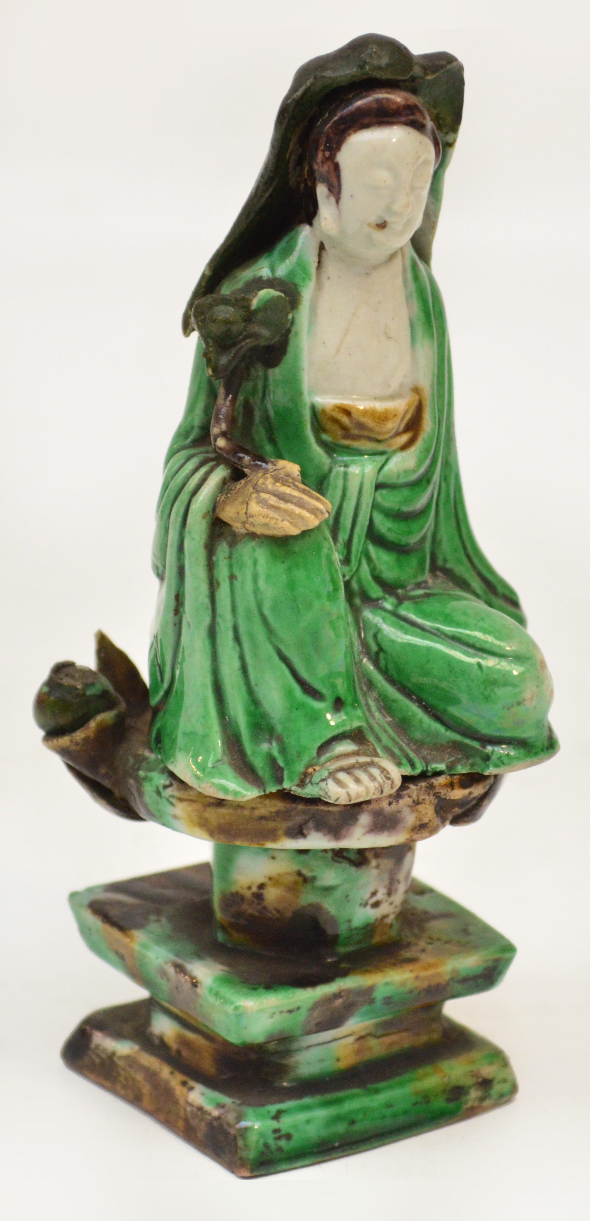 A Chinese Kangxi Sancai glazed model of a deity seated upon a lotus throne, bears label "No.442