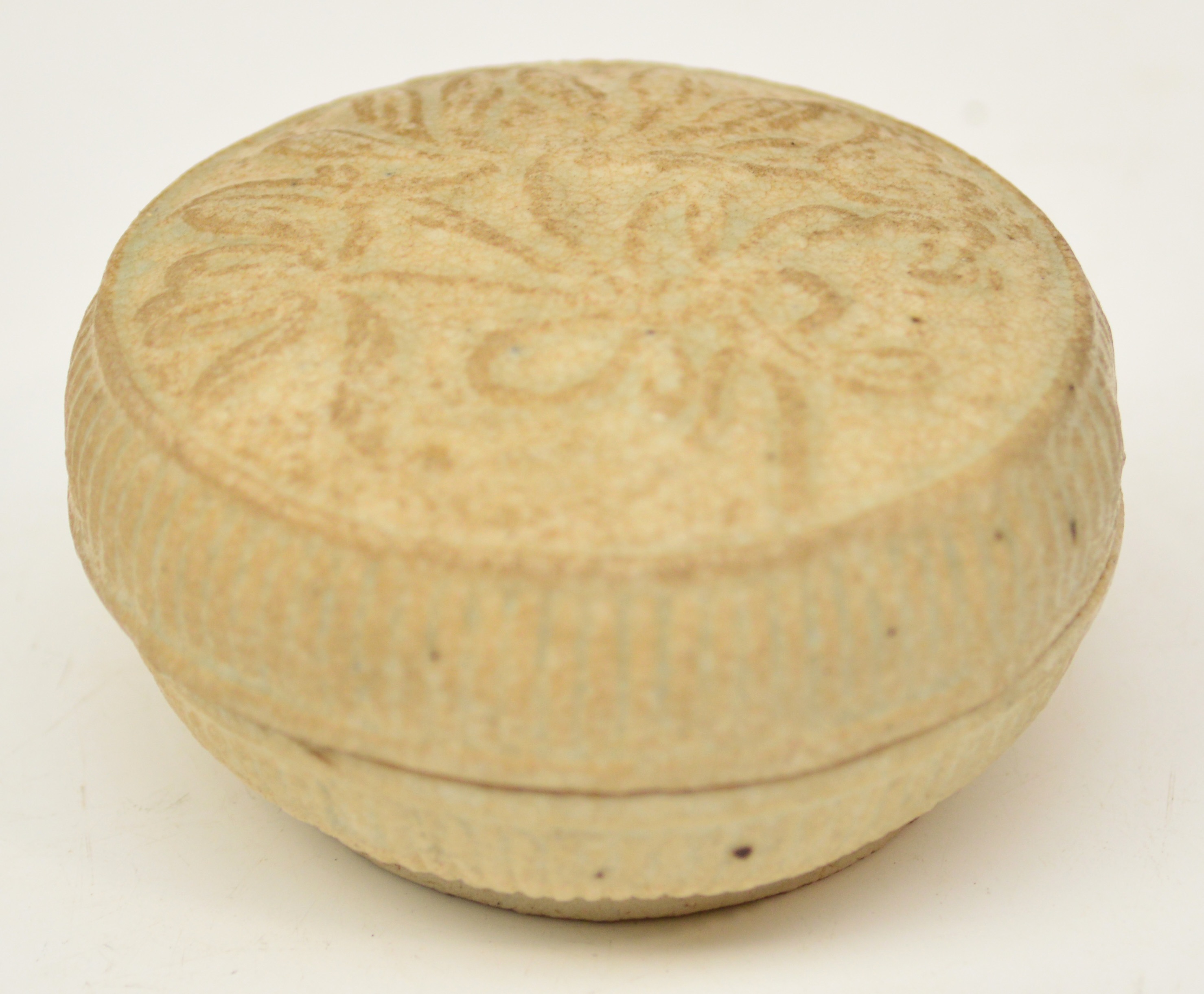 A 14th century Chinese porcelain Qingbai glazed circular box and cover, the lid decorated in