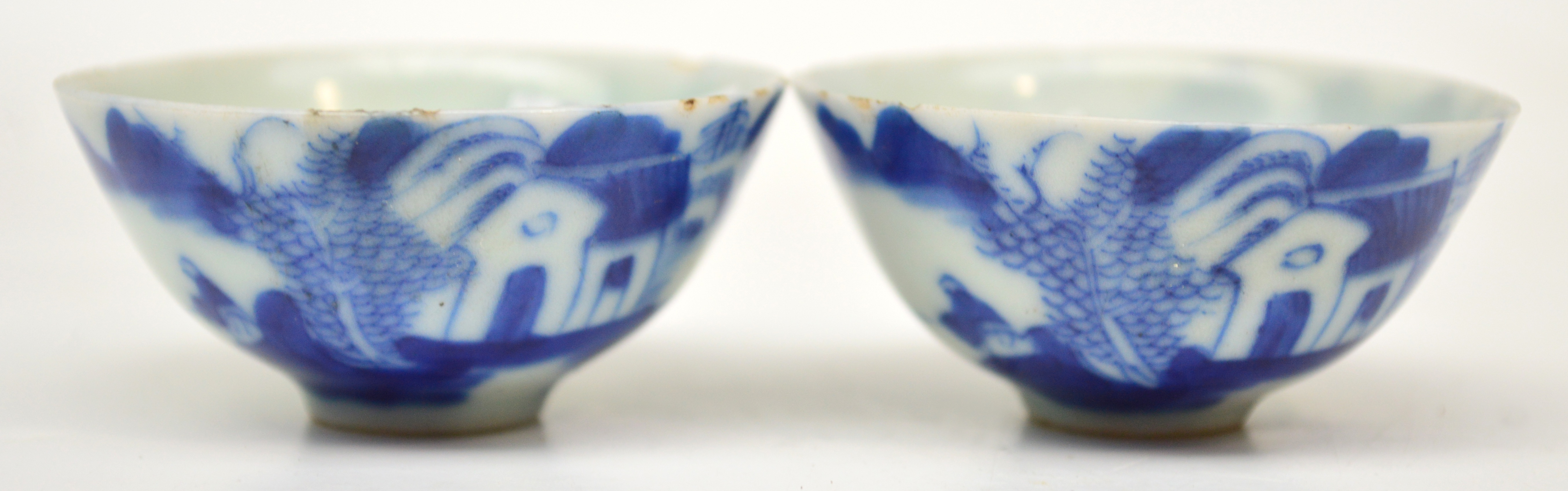 A pair of Chinese Qianlong period porcelain tea bowls painted in underglaze blue with a continuous