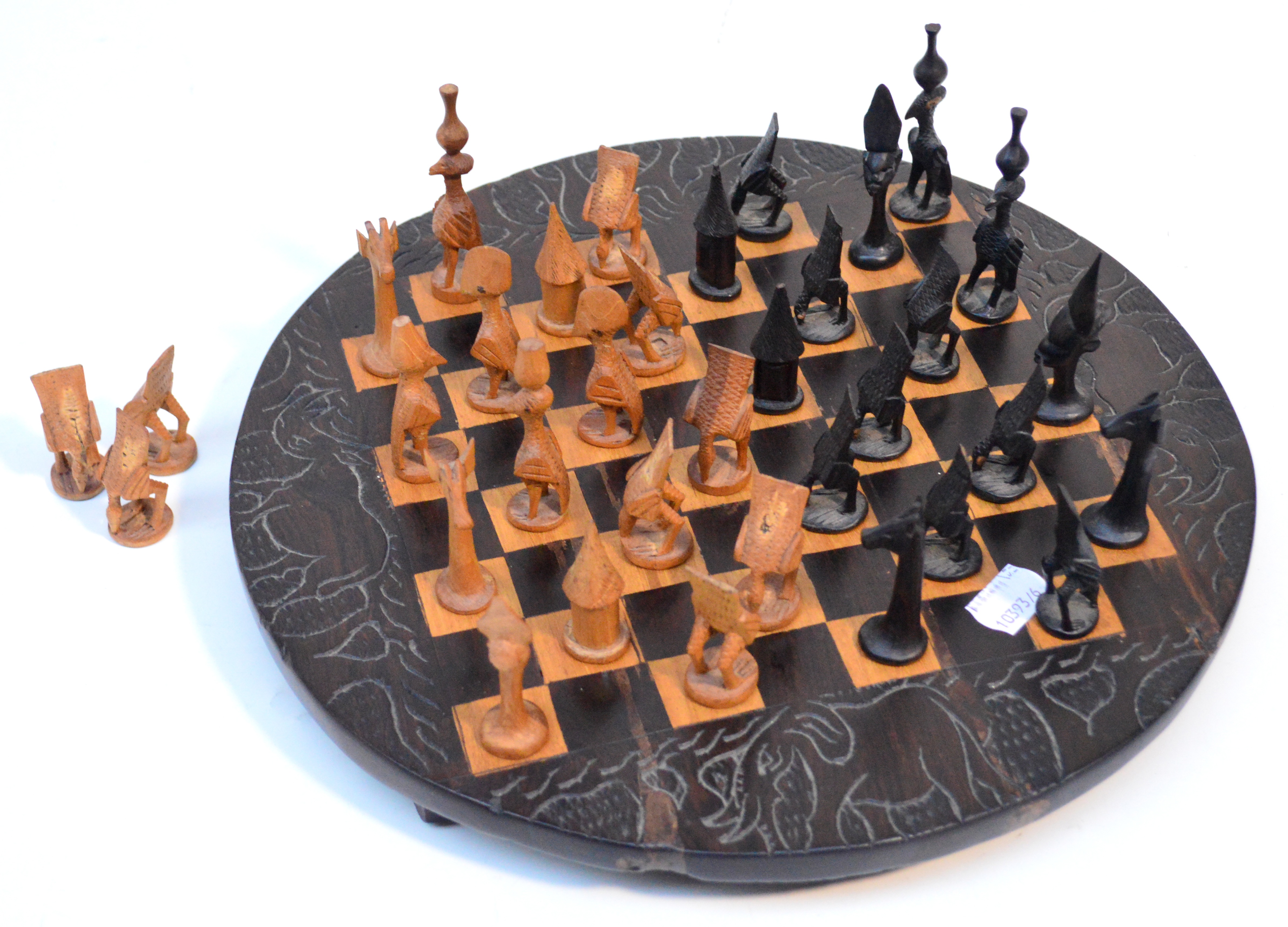 A carved wooden chess set and board, each piece carved as an animal.