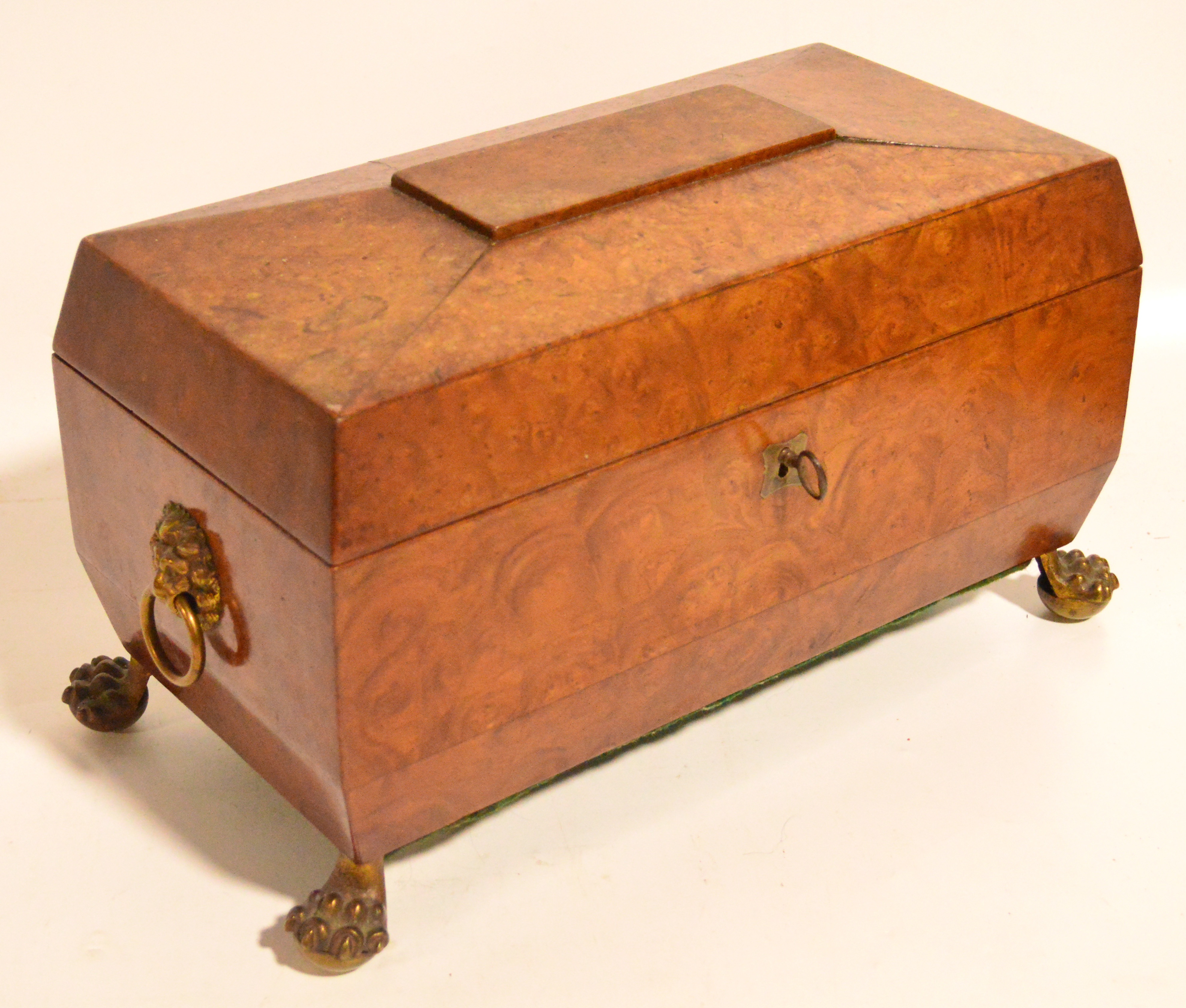 A burr walnut Victorian sarcophagus form tea caddy, the hinged lid enclosing two lidded compartments