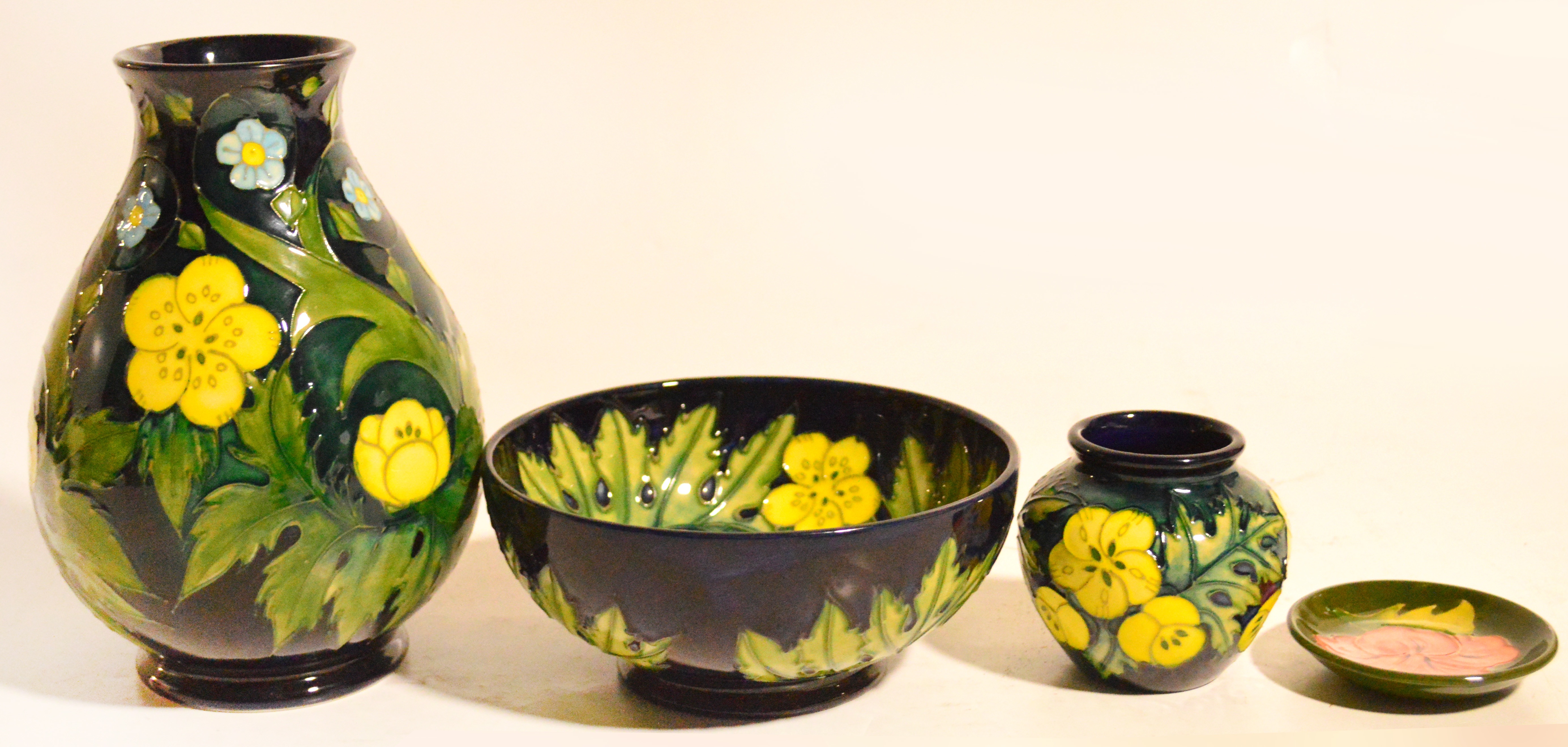 Three pieces of Moorcroft pottery decorated in the "Buttercup" design, comprising baluster vase,