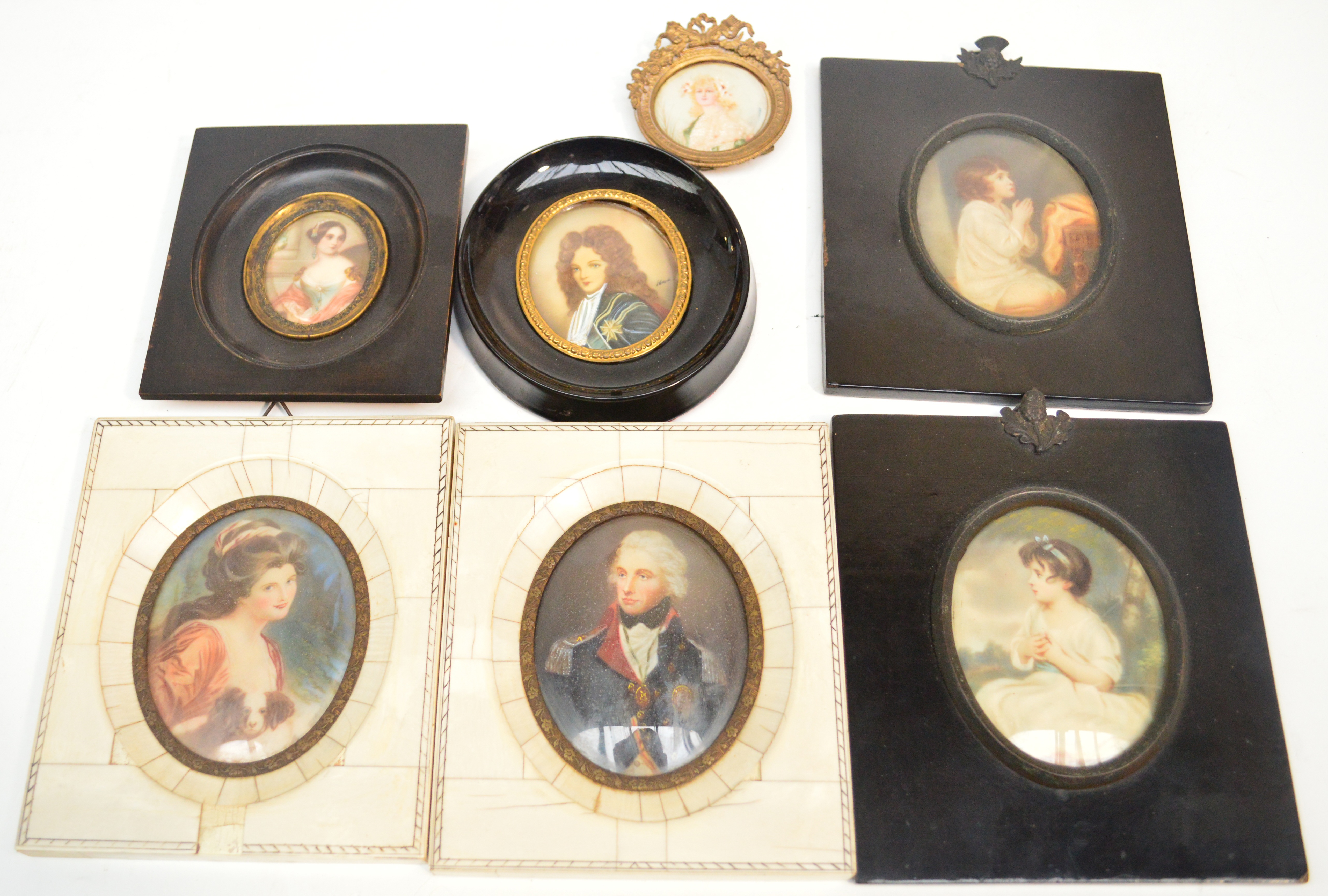 A pair of 20th century portrait miniatures in piano key frames, a further pair of oval portrait