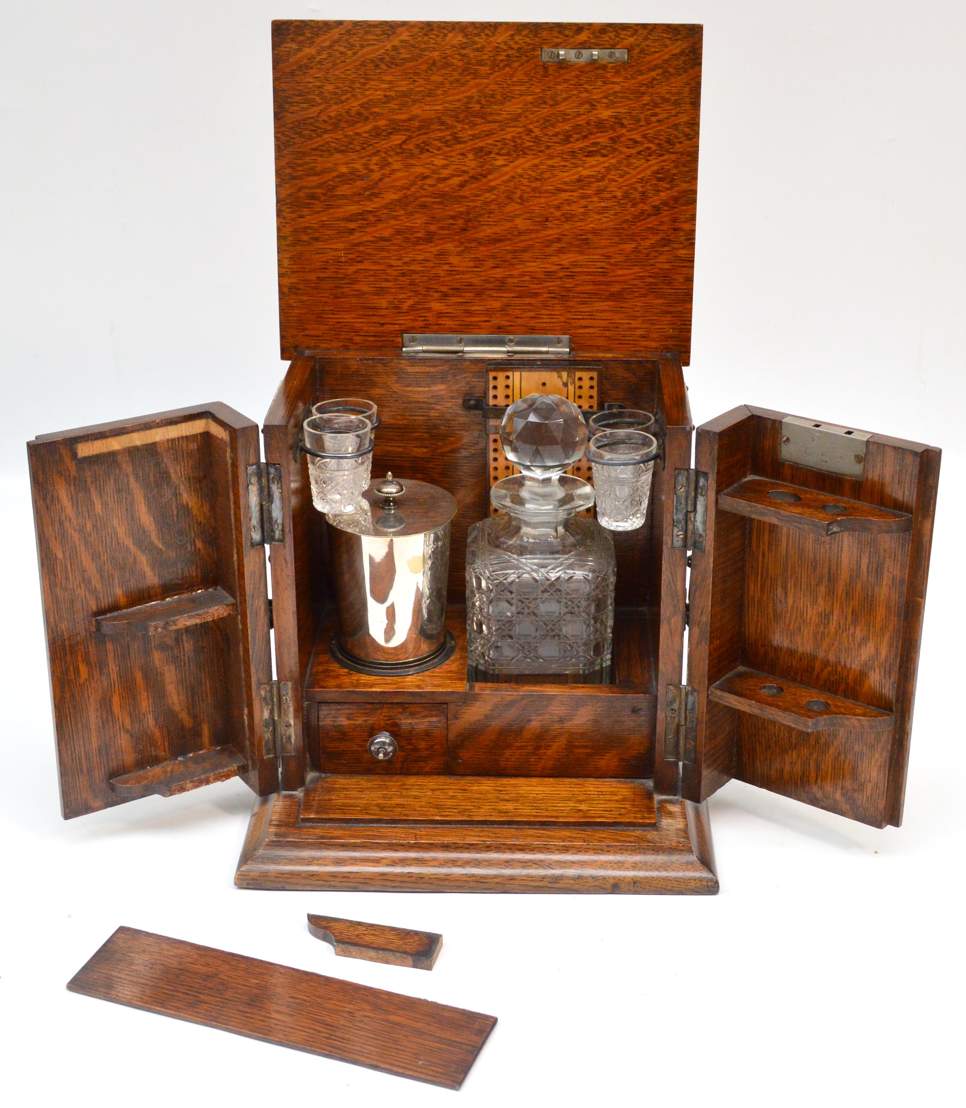 An Edwardian oak gentleman's travelling set with plated mounts, the hinged lid enclosing cut glass