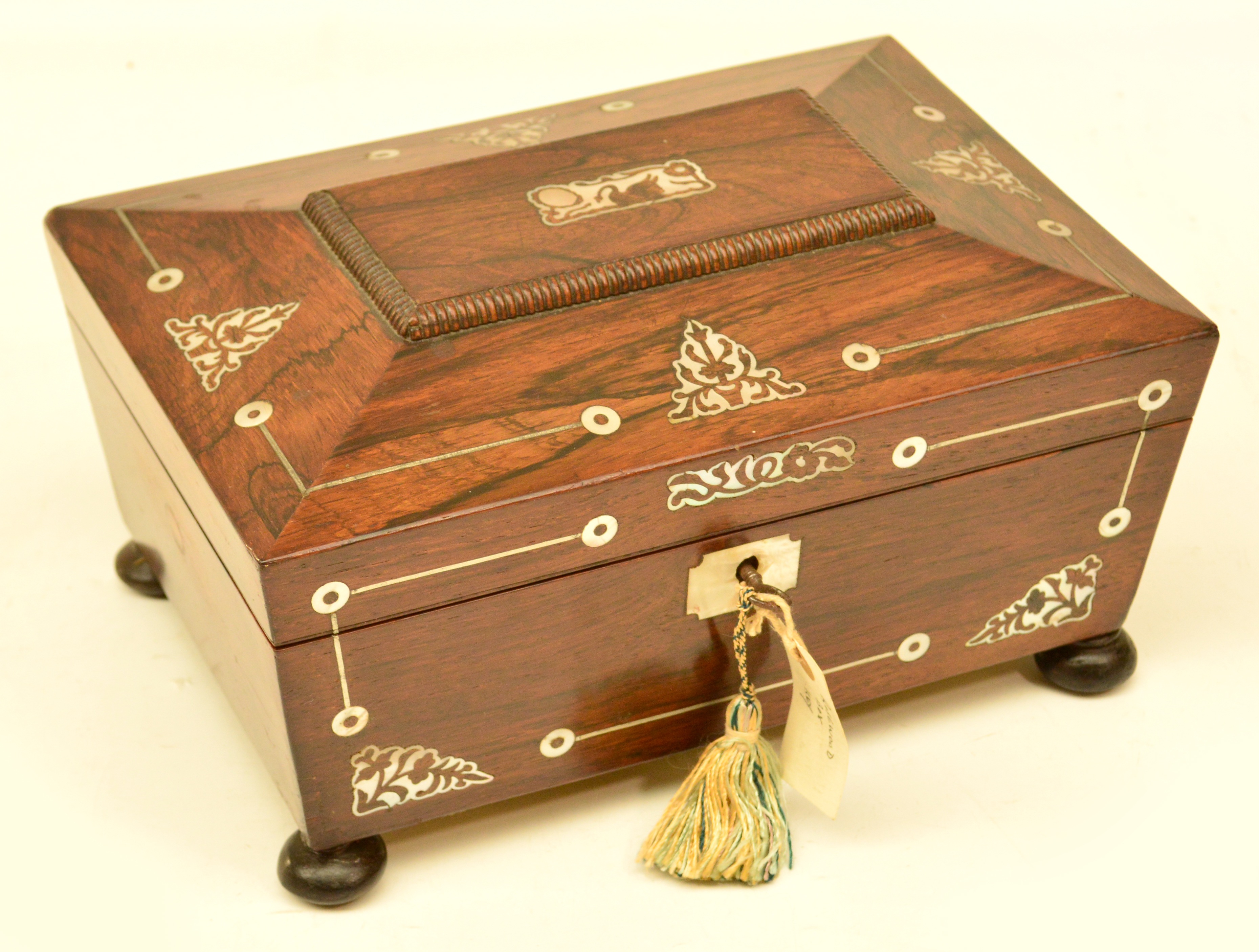 An early Victorian rosewood mother of pearl inlaid travelling box of sarcophagus form, the hinged