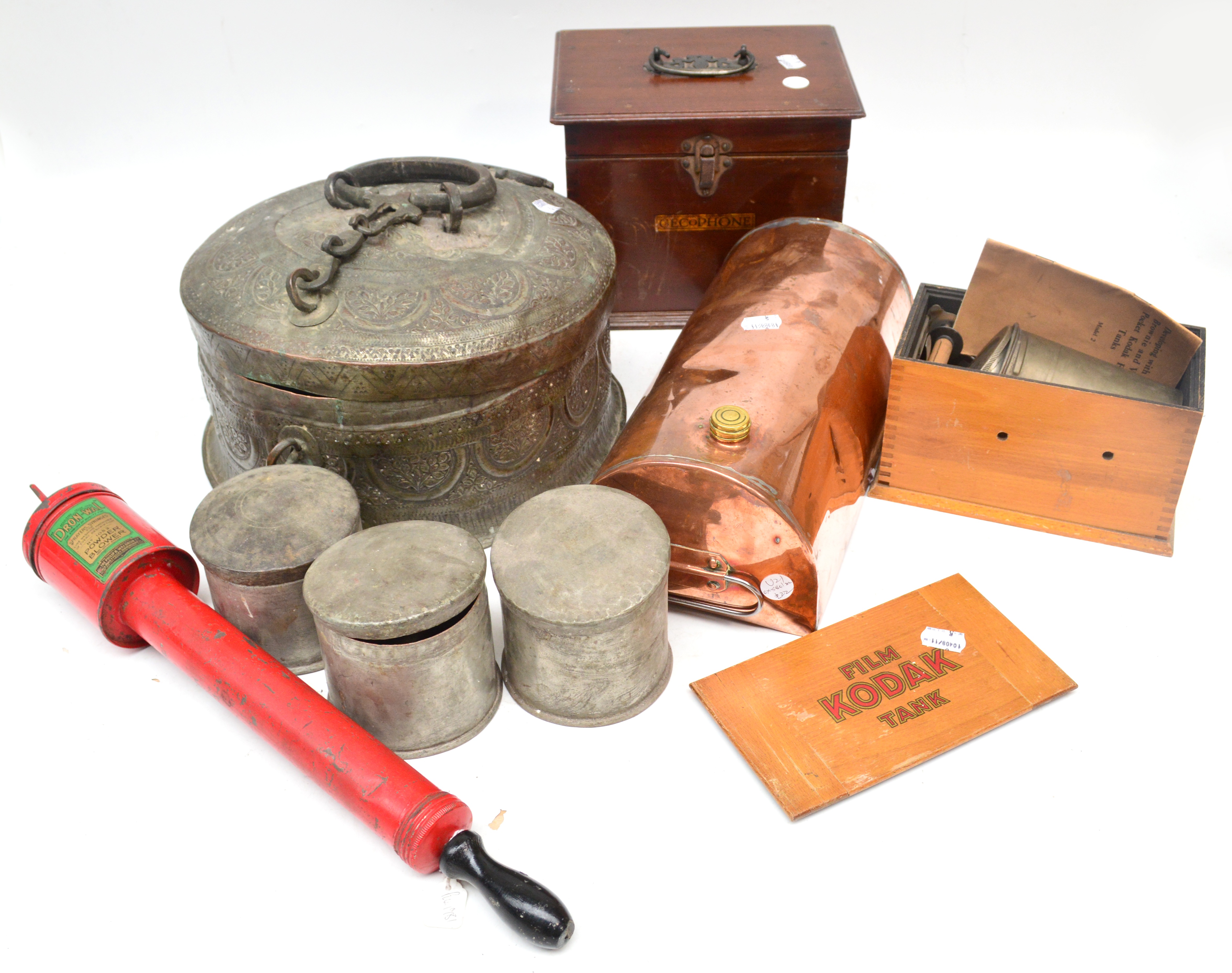 An Eastern embossed metal food carrying tin, a Kodak film tank, a copper warming pan, a powder