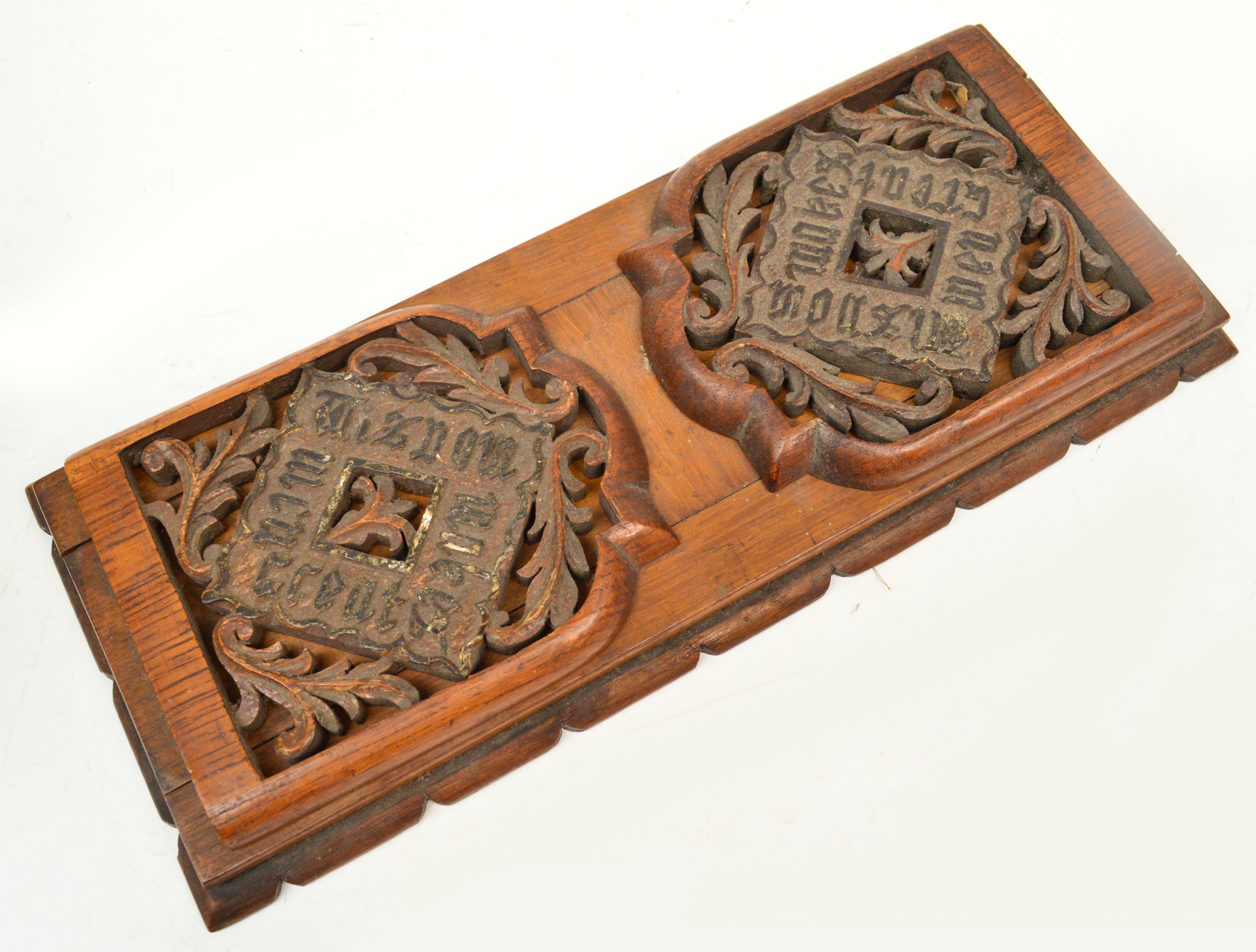 An early 20th century oak bookslide with carved and pierced flaps, the flaps inscribed "Wisdom Makes