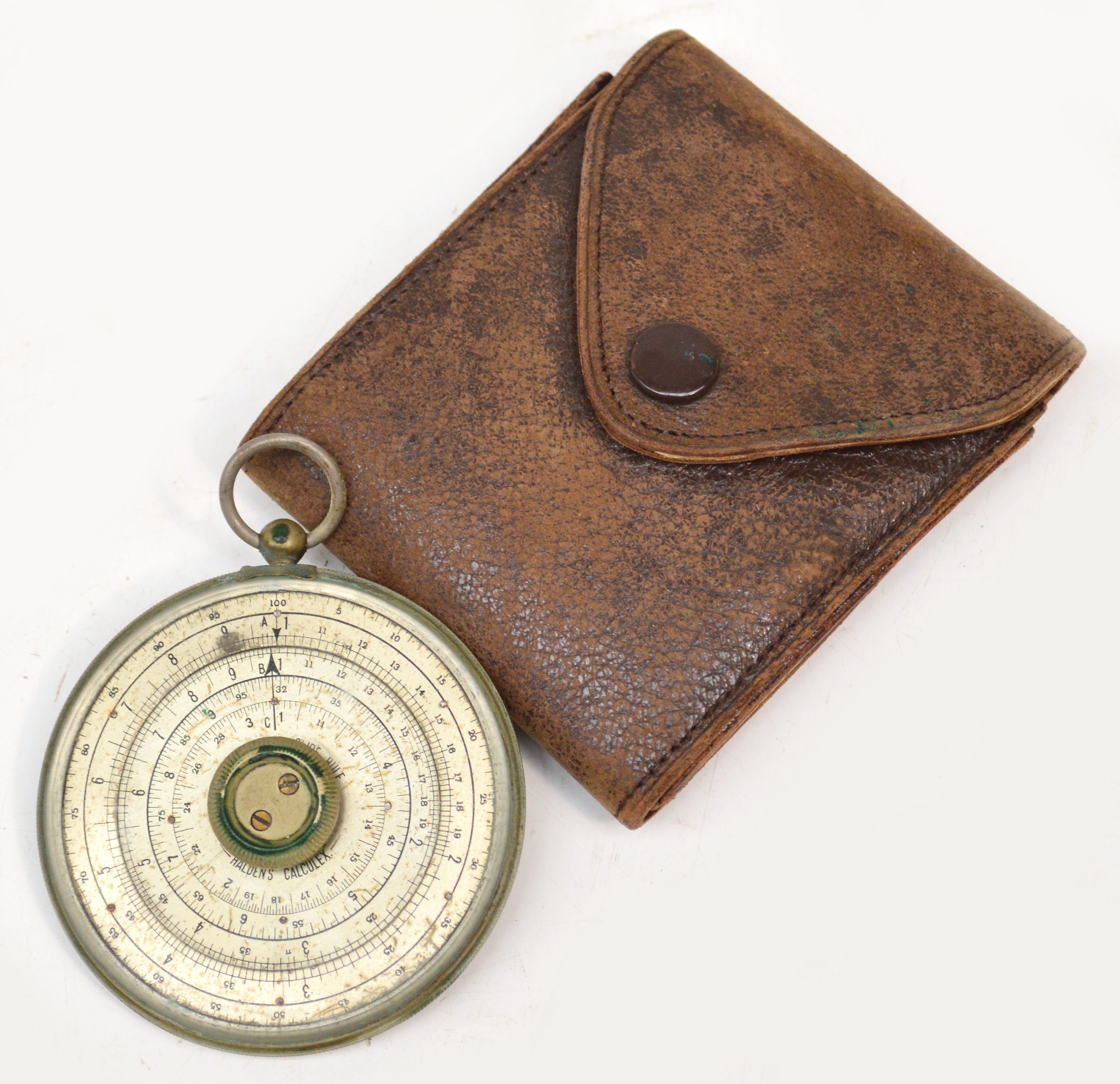 A leather cased Haldens calculex of circular form, diameter 6cm.