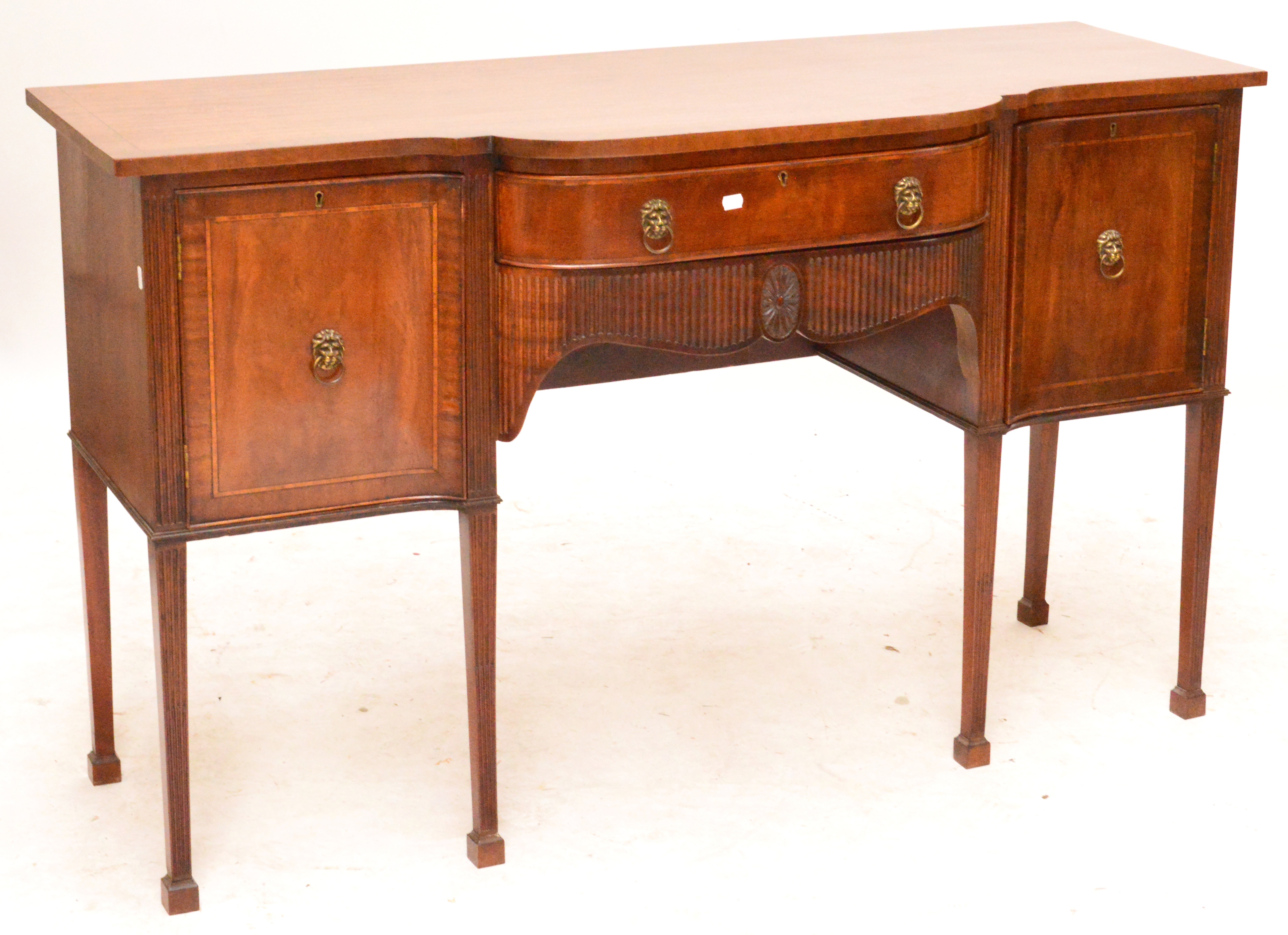 An Edwardian mahogany crossbanded breakfront sideboard with lion mask ring handles, the central