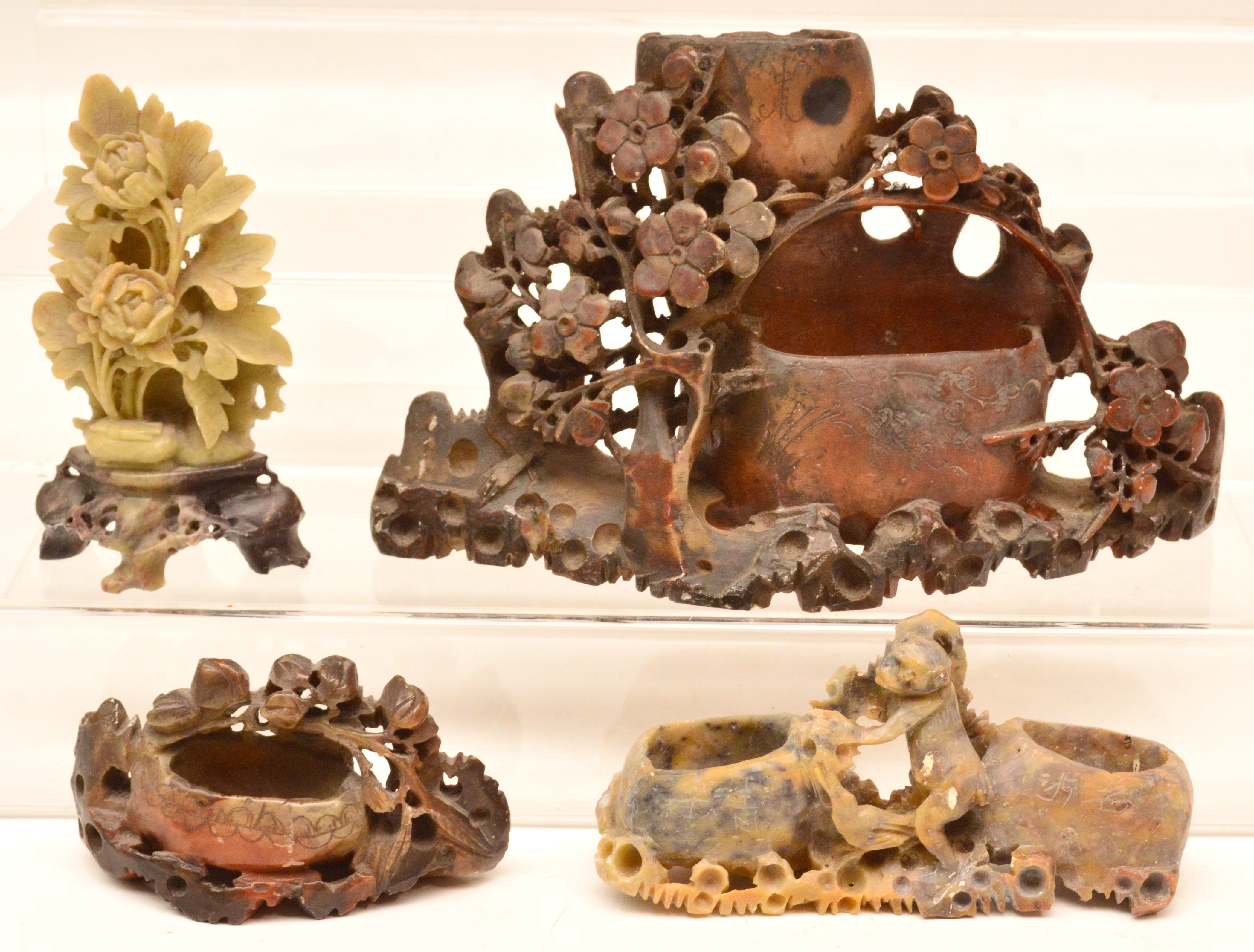 Four early 20th century Oriental soapstone carvings, one centred with a monkey.