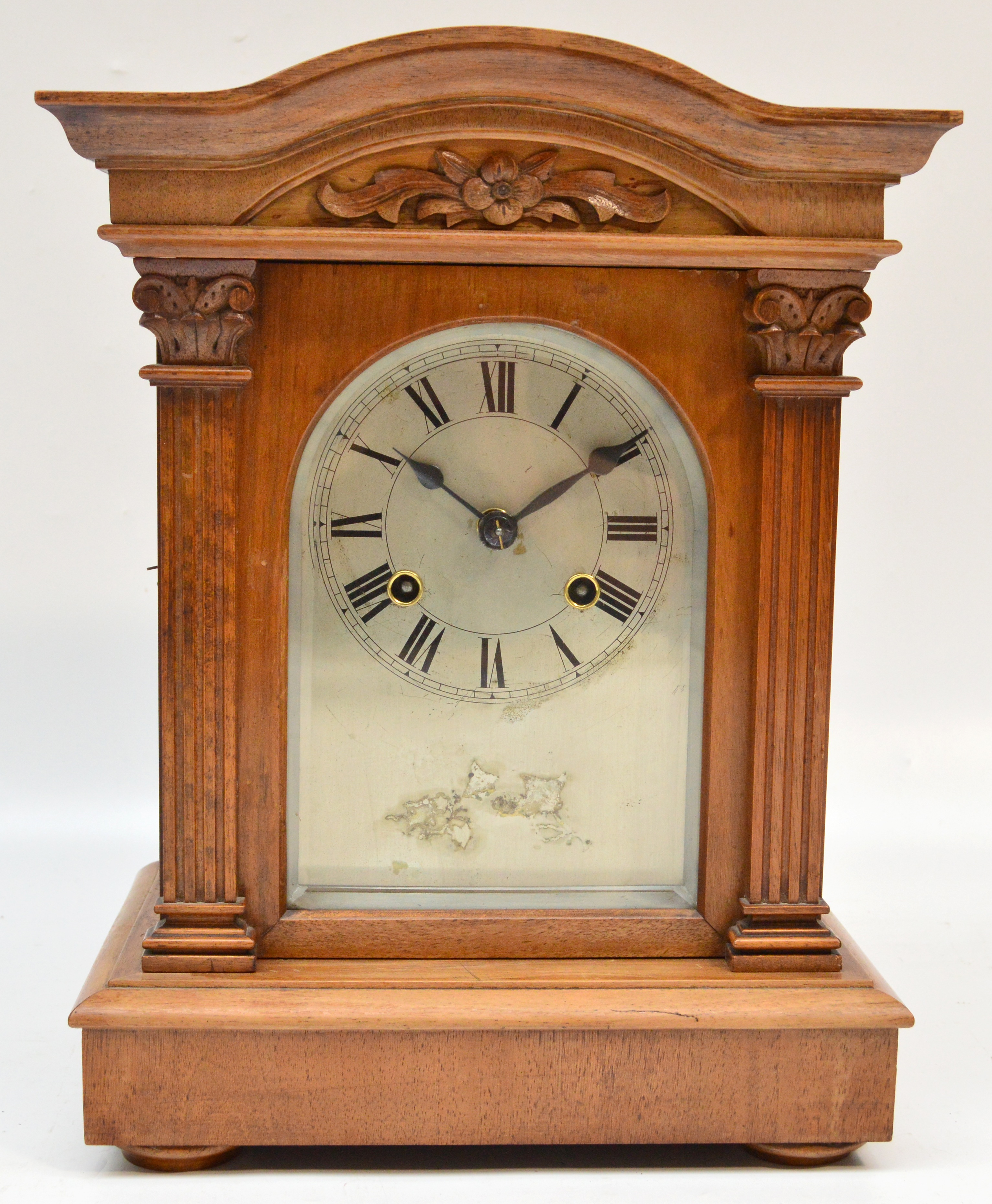 A late 19th century walnut eight day mantel clock, the silvered dial set with Roman numerals and