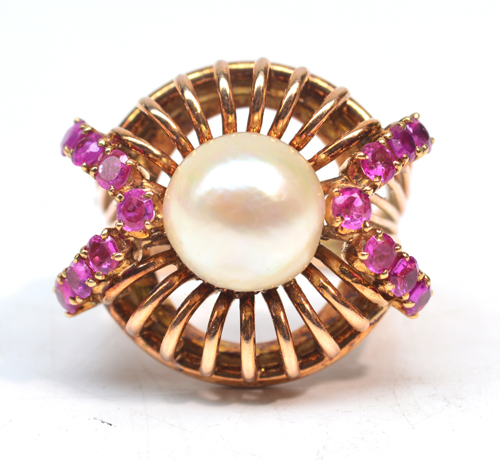 A yellow metal dress ring with central cultured pearl flanked by two chevron set rows of pink tinted