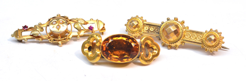 An Edwardian 9ct gold floral decorated bar brooch, a yellow metal brooch centred with an oval