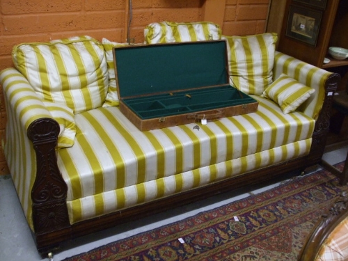 A William IV Carved Mahogany Ottoman, the shaped and upholstered ends with shell and foliate