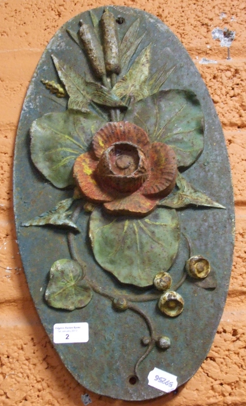 A Cast Metal Oval Wall Plaque with poppy and foliage in relief.