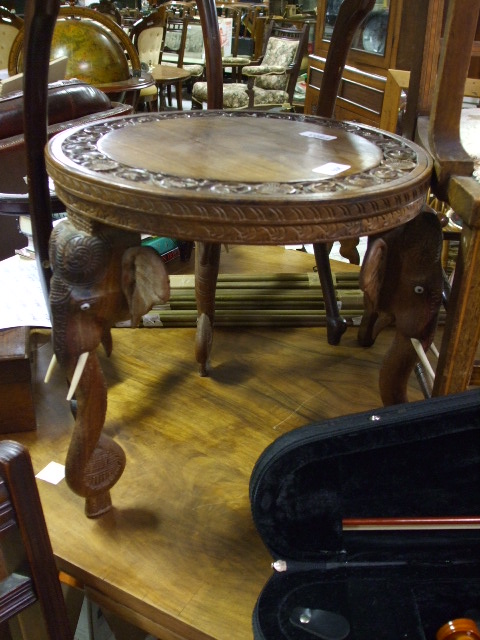 A Carved Rosewood Tribal Stool, the circular top supported by three legs modelled as elephants.