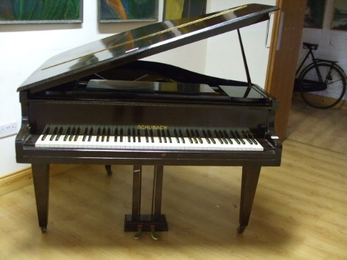 A Baby Grand Piano by Schubach, the mahogany case on square tapered legs, d. 123 x w. 137 cm.