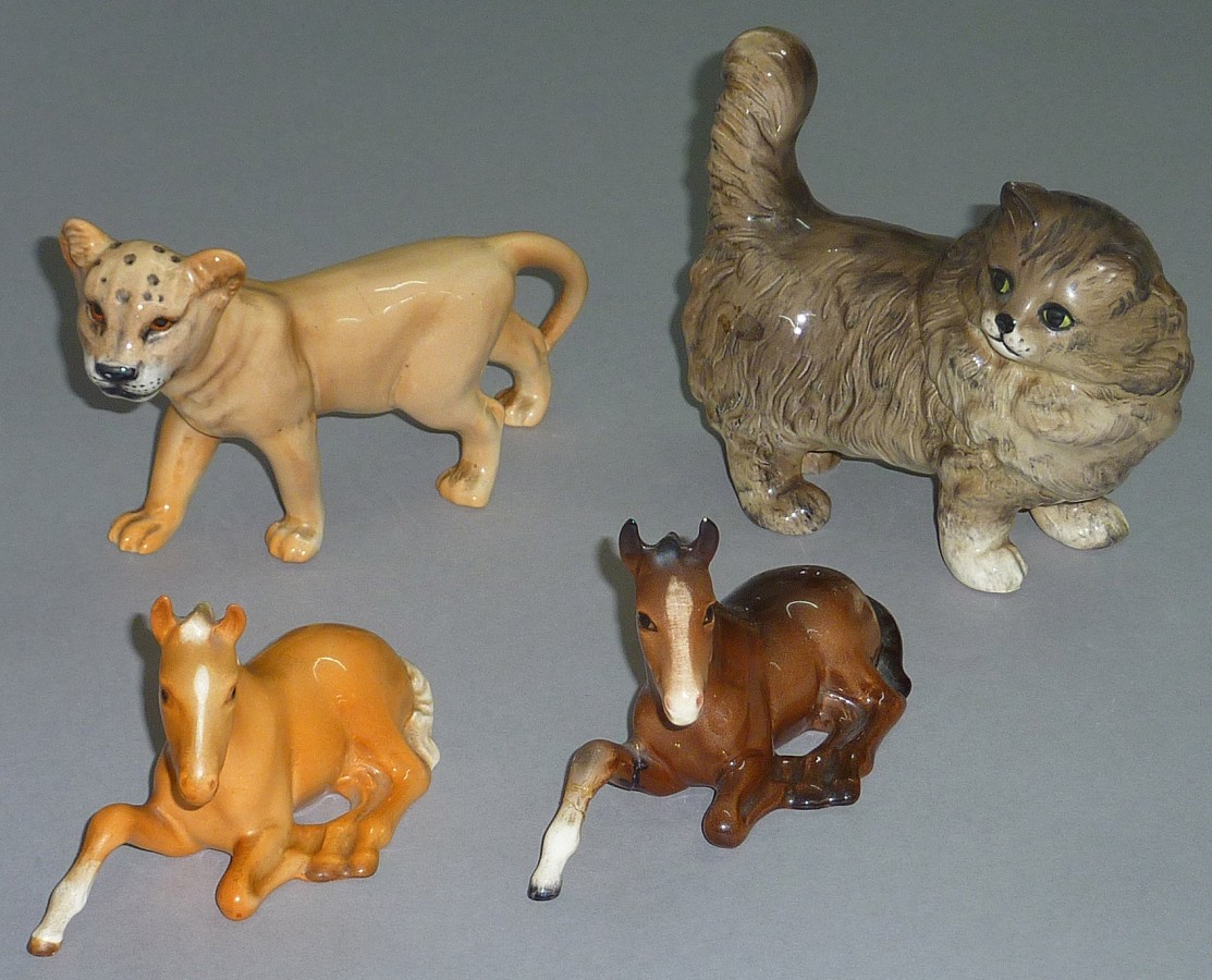 Beswick cat ornament, together with a puma cub and two horses.