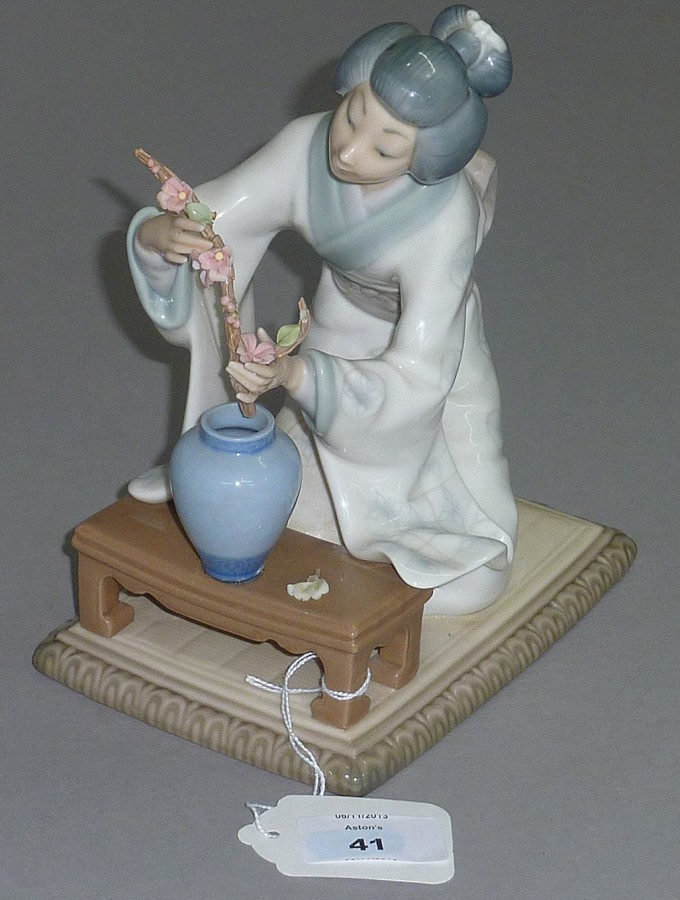 Lladro figure of a lady arranging flowers.