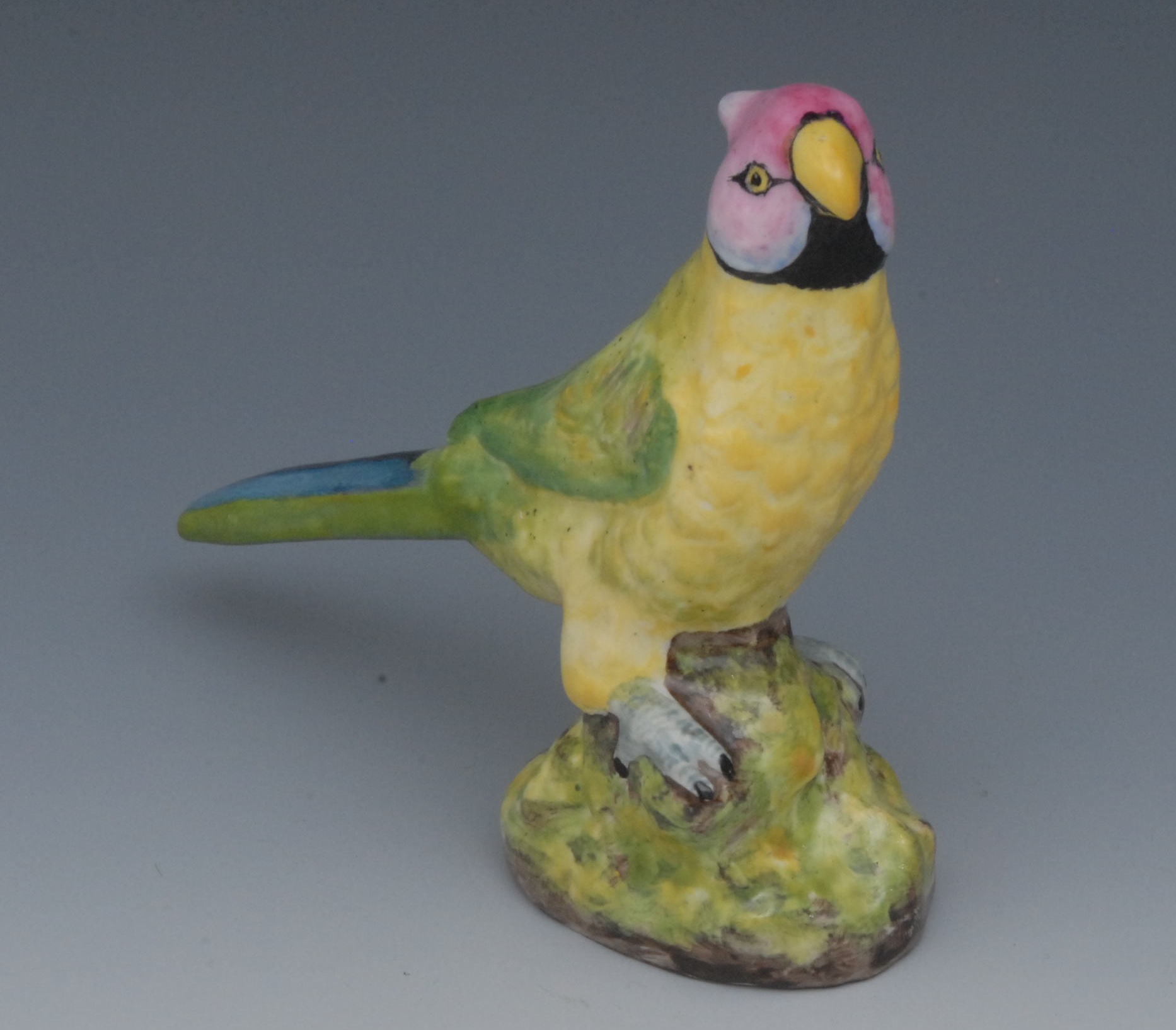 A Sampson Hancock parrot, brightly enamelled, perched on a mound, 11.25cm high, S, H, crown, crossed