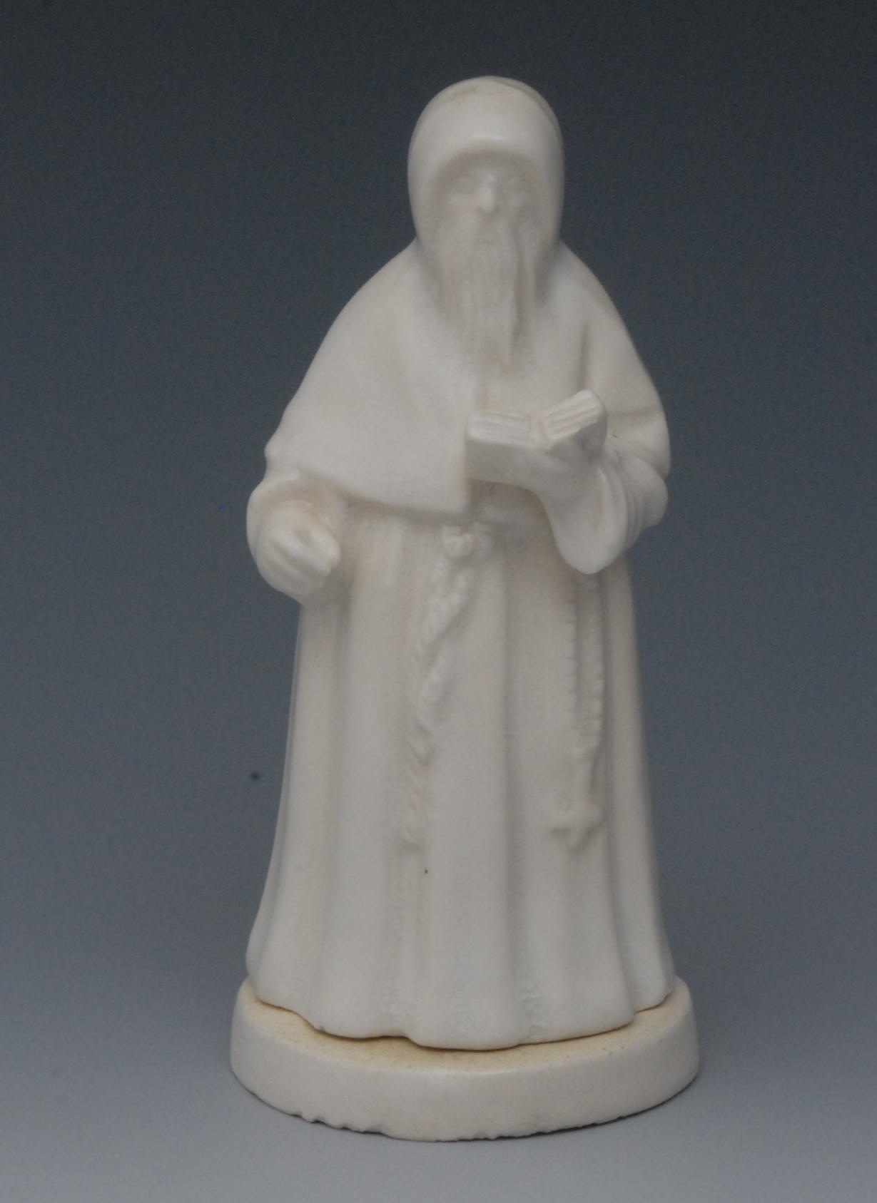 A Sampson Hancock Derby novelty candle snuffer, The Monk, in the white, he stands in habit holding a