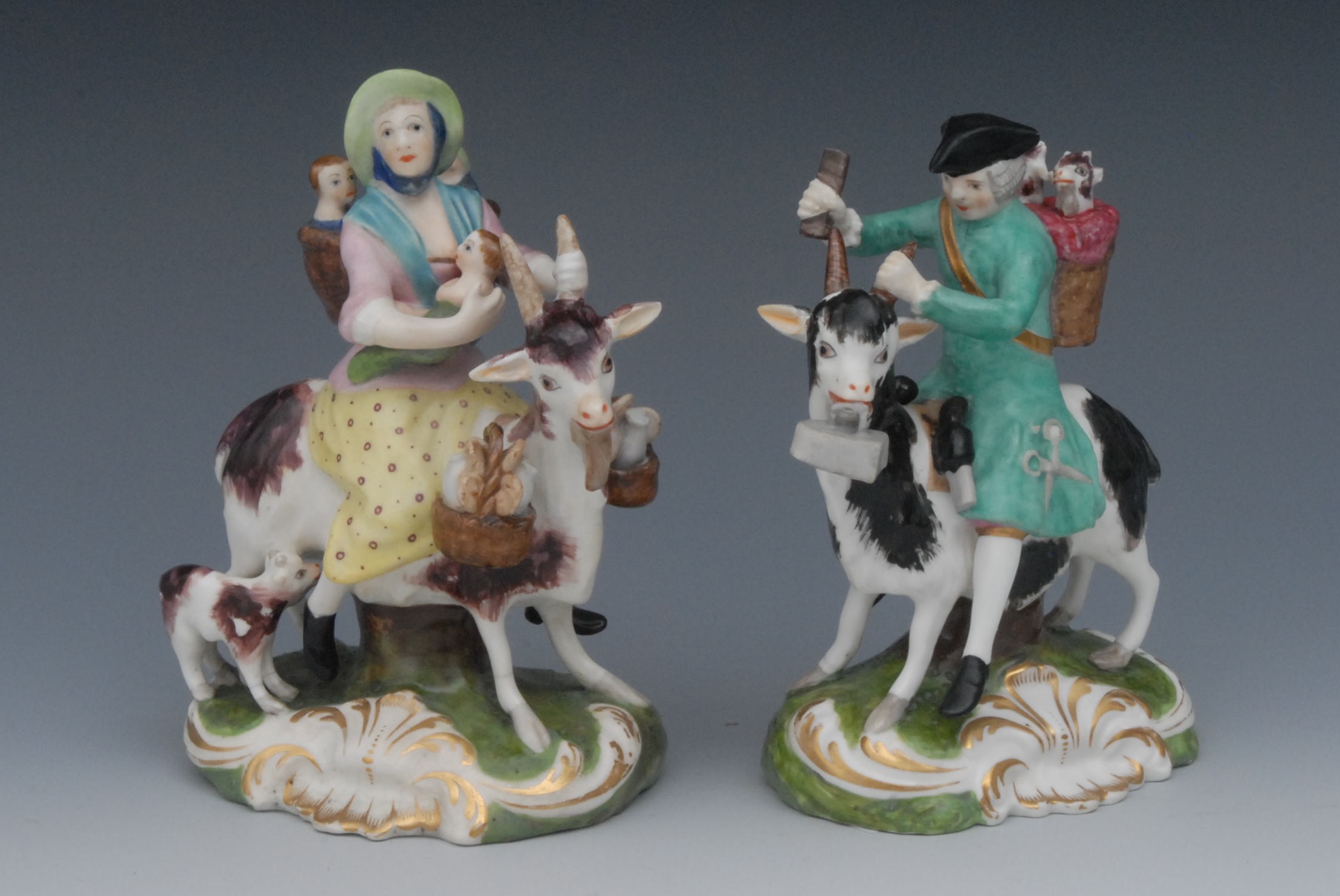 A pair of Sampson Hancock Derby figures, The Welsh Tailor and his Wife, each astride a goat, the
