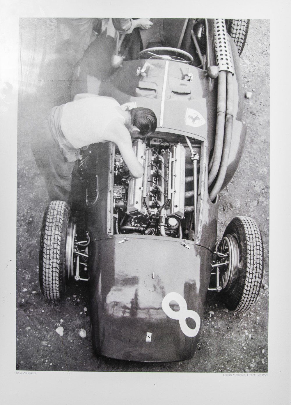 A framed print of a Jesse Alexander photograph, Ferrari mechanic, French Grand Prix, 1954
