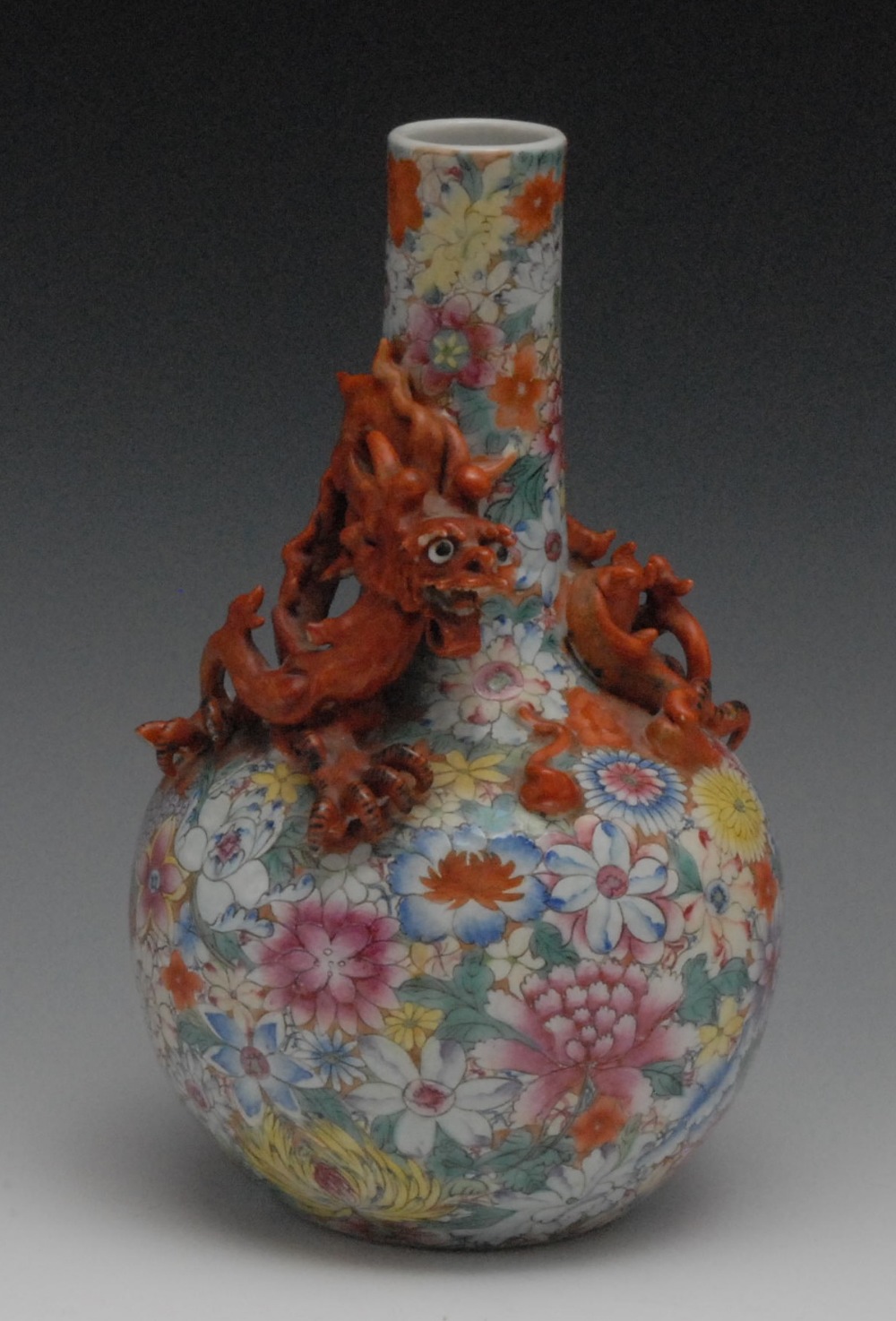 A Chinese bottle vase, decorated overall with colourful flowerheads, the neck applied with scrolling