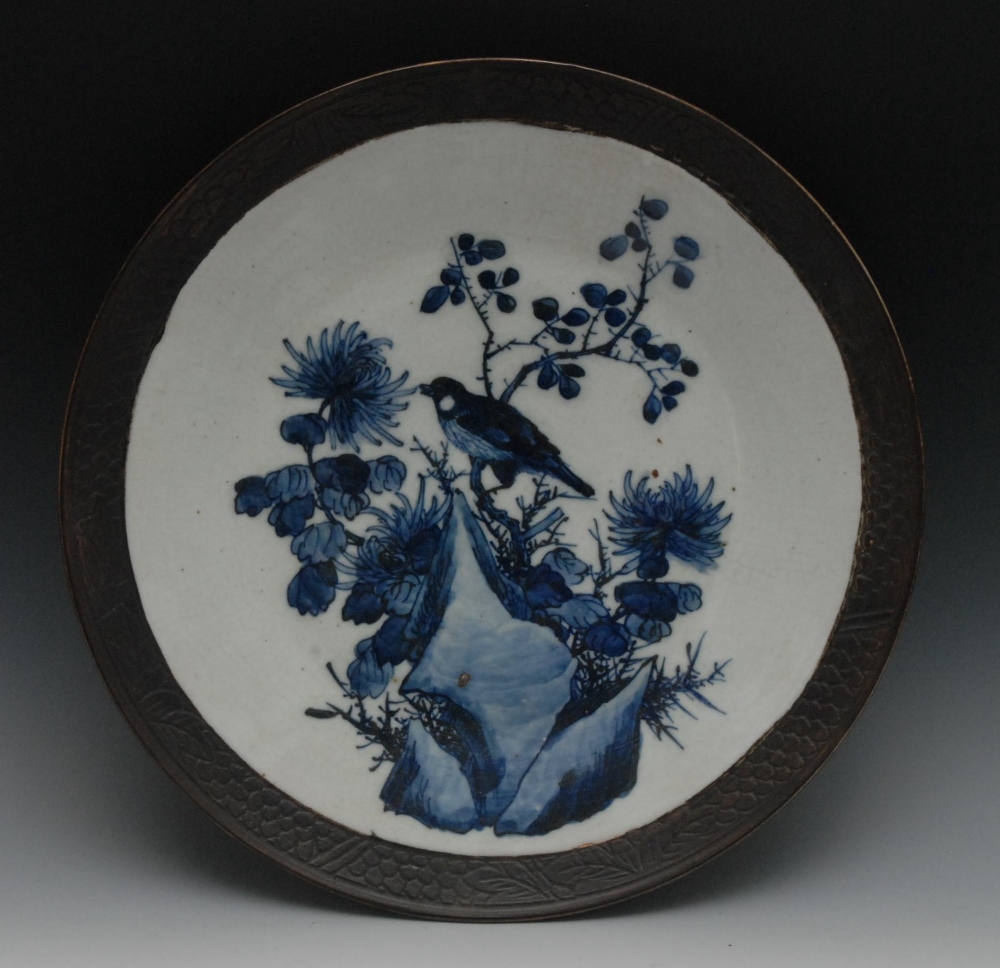 A Chinese circular charger, painted in underglaze blue with song bird perched on a branch, brown