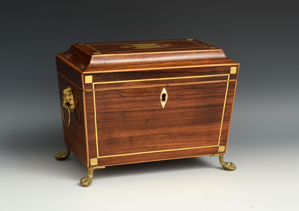 A Regency rosewood and brass marquetry sarcophagus tea caddy, hinged cover enclosing a pair of