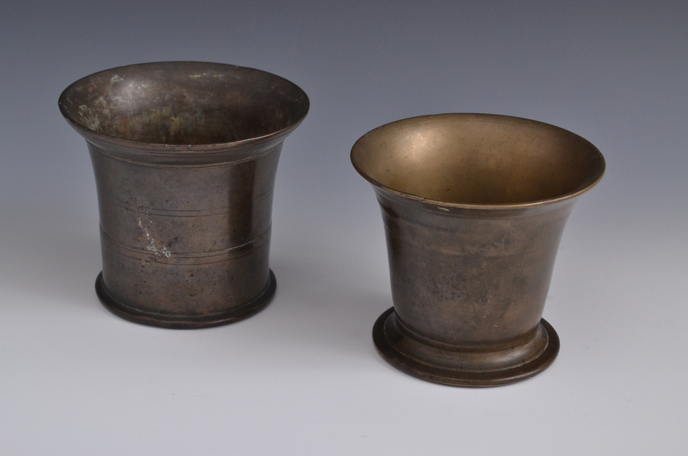 An early 18th century bronze mortar, flared rim, skirted base, 11cm high, c.1720; another (2)