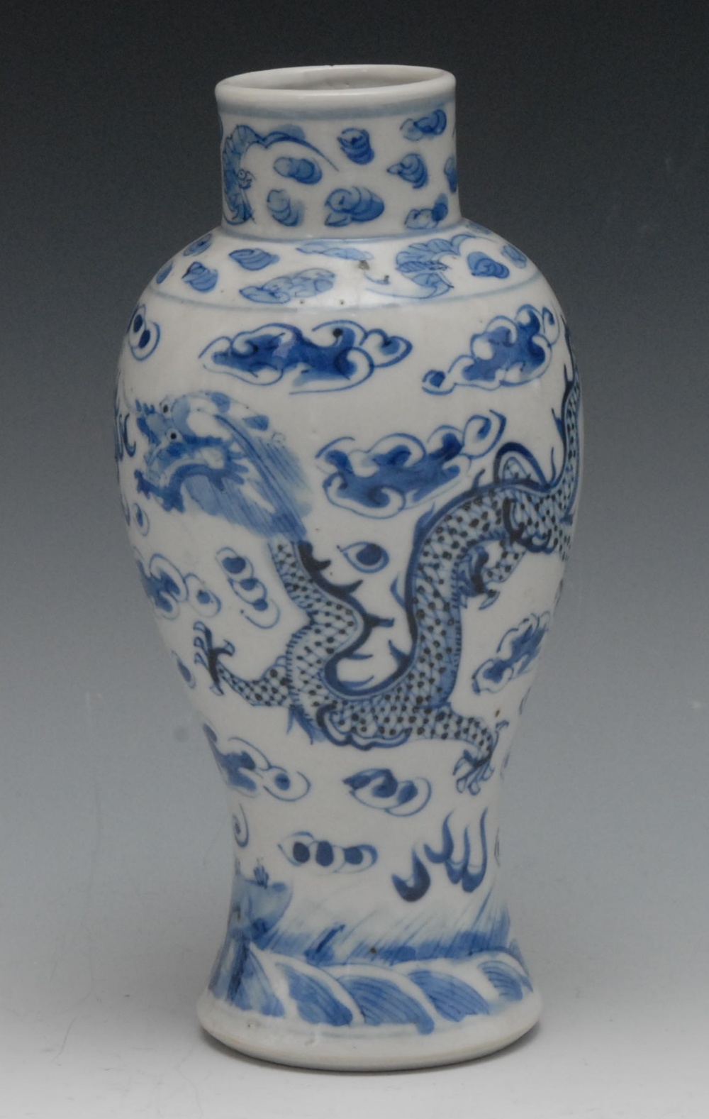 A Chinese baluster vase and cover, painted in underglaze blue with dragons chasing the flaming