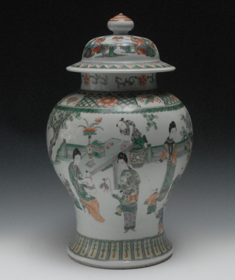A 19th century Chinese Famille Verte inverted baluster vase and cover, painted with oriental