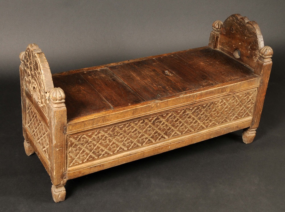 An Indonesian rice chest, the shaped arched ends carved with stylised leaves and diapers, 59cm high,