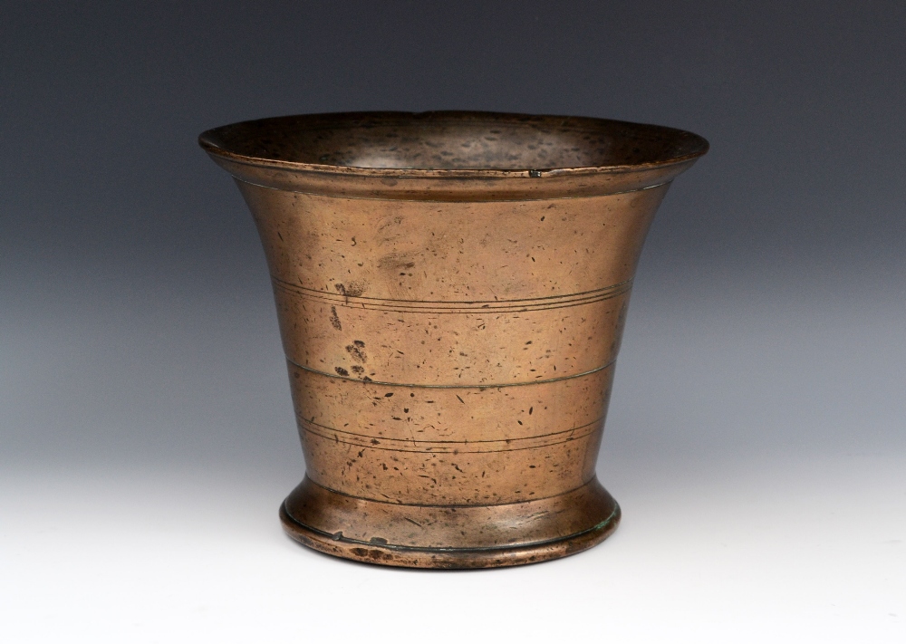 A 17th/early 18th century bronze mortar, flared rim, skirted base, 14.5cm high, c.1680 - 1720