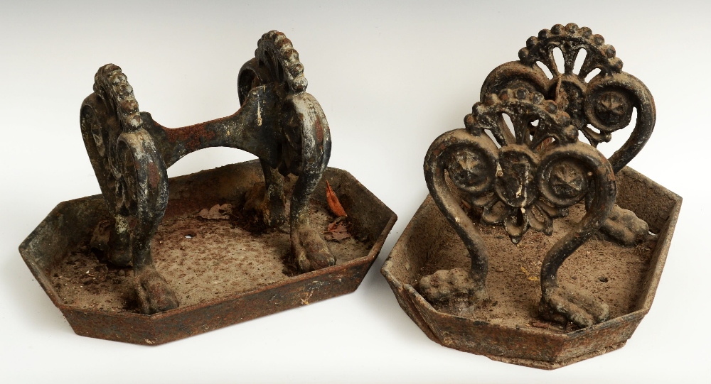 A pair of George III cast iron boot scrapers, bold scroll end supports terminating in lion paw feet,