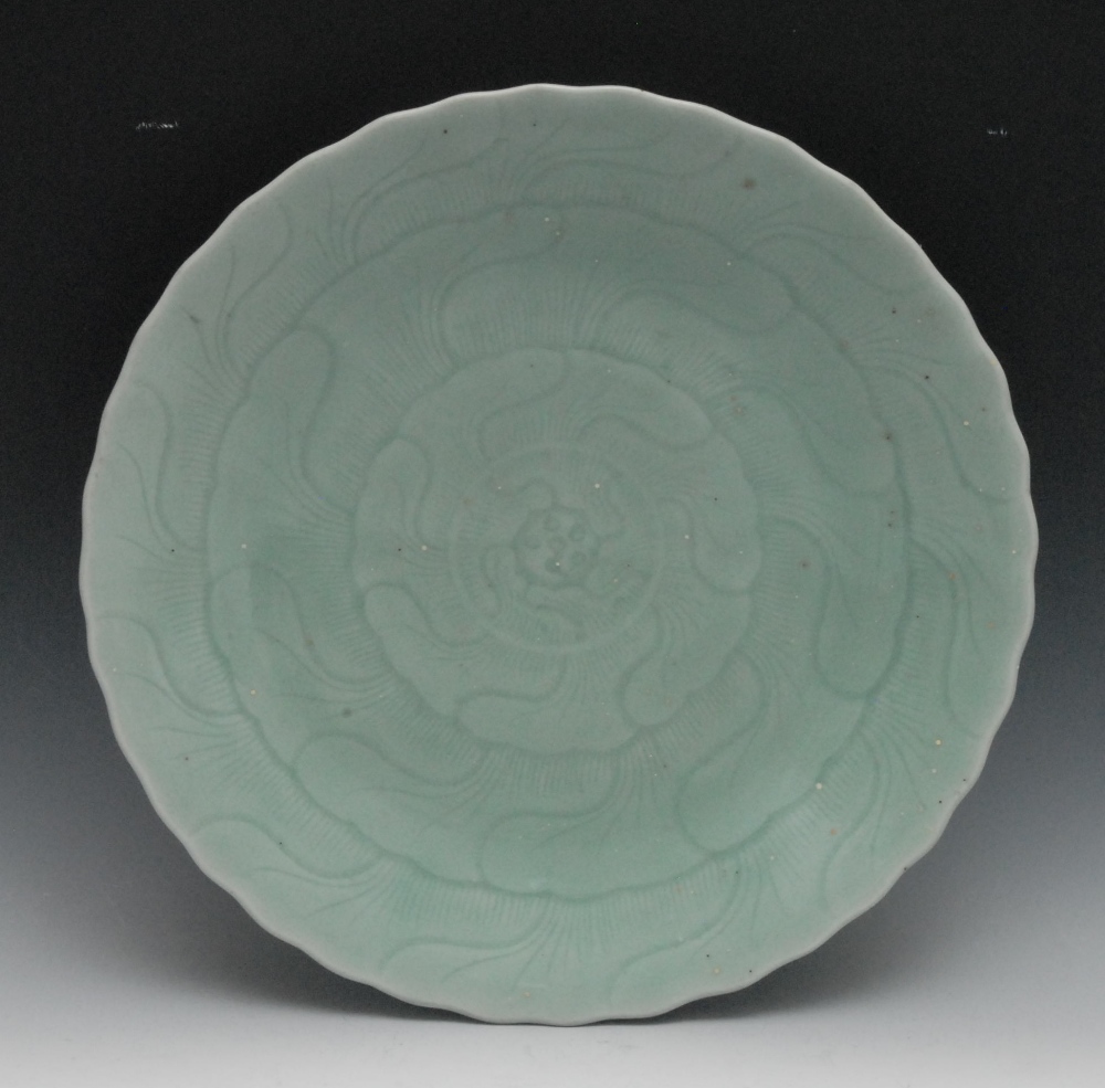 A 20th century celadon shaped circular dish, incised with lotus, 36cm diam, 20th century