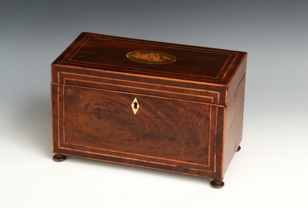 A George III mahogany rectangular tea caddy, hinged cover inlaid with an oval shell patera,