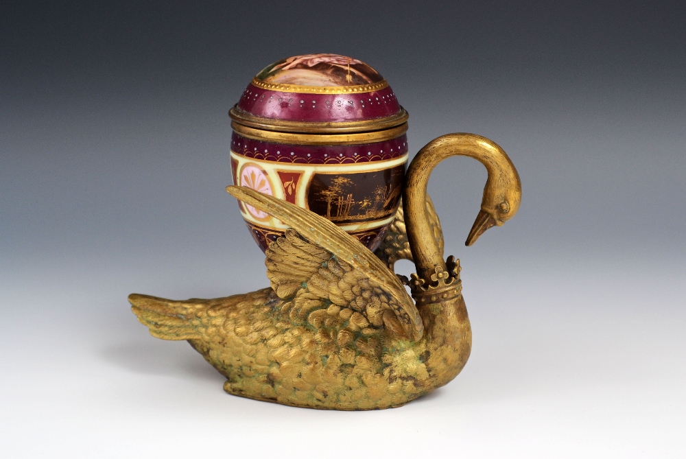 A 19th century Continental porcelain mounted bronze ikwell, cast as a swan, the well with hinged