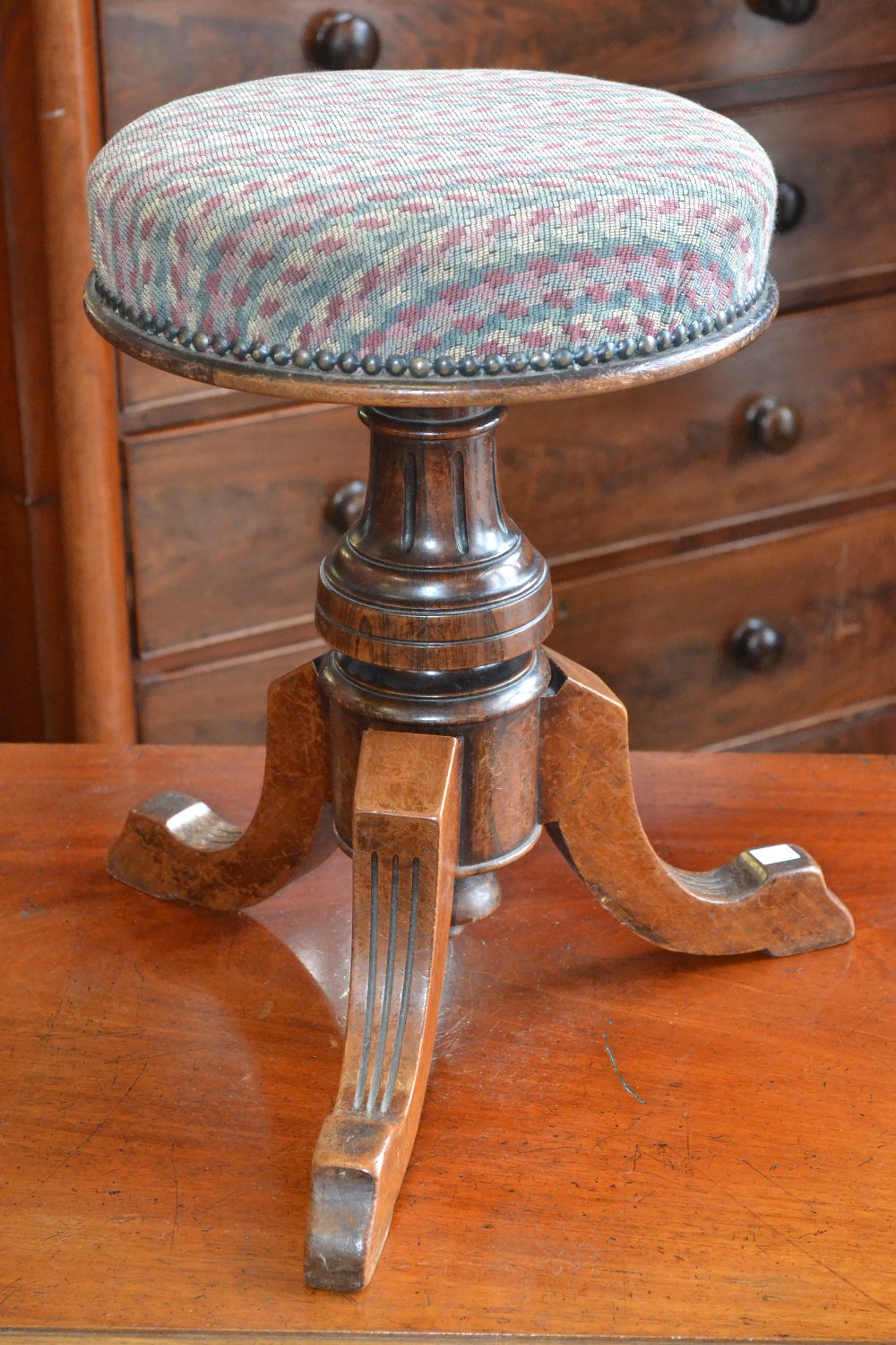 A Victorian mahogany and rosewood circular extending piano stool