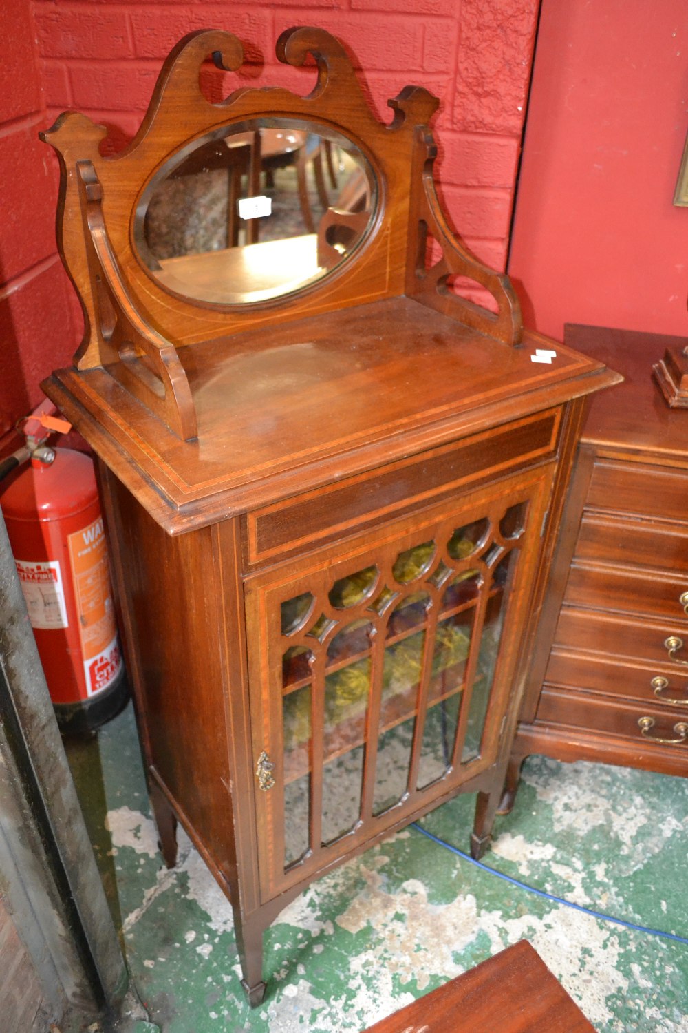 An Edwardian inlaid mirror back music cabinet