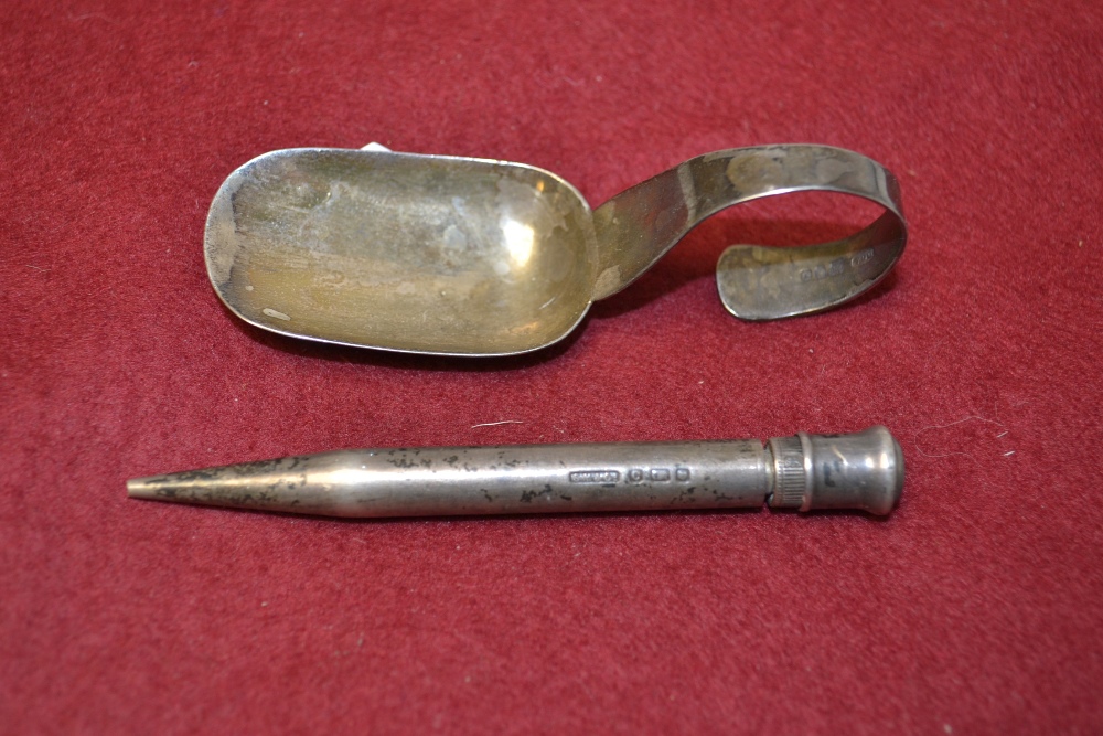 A silver caddy spoon, London 1923; a silver propelling pencil (2)