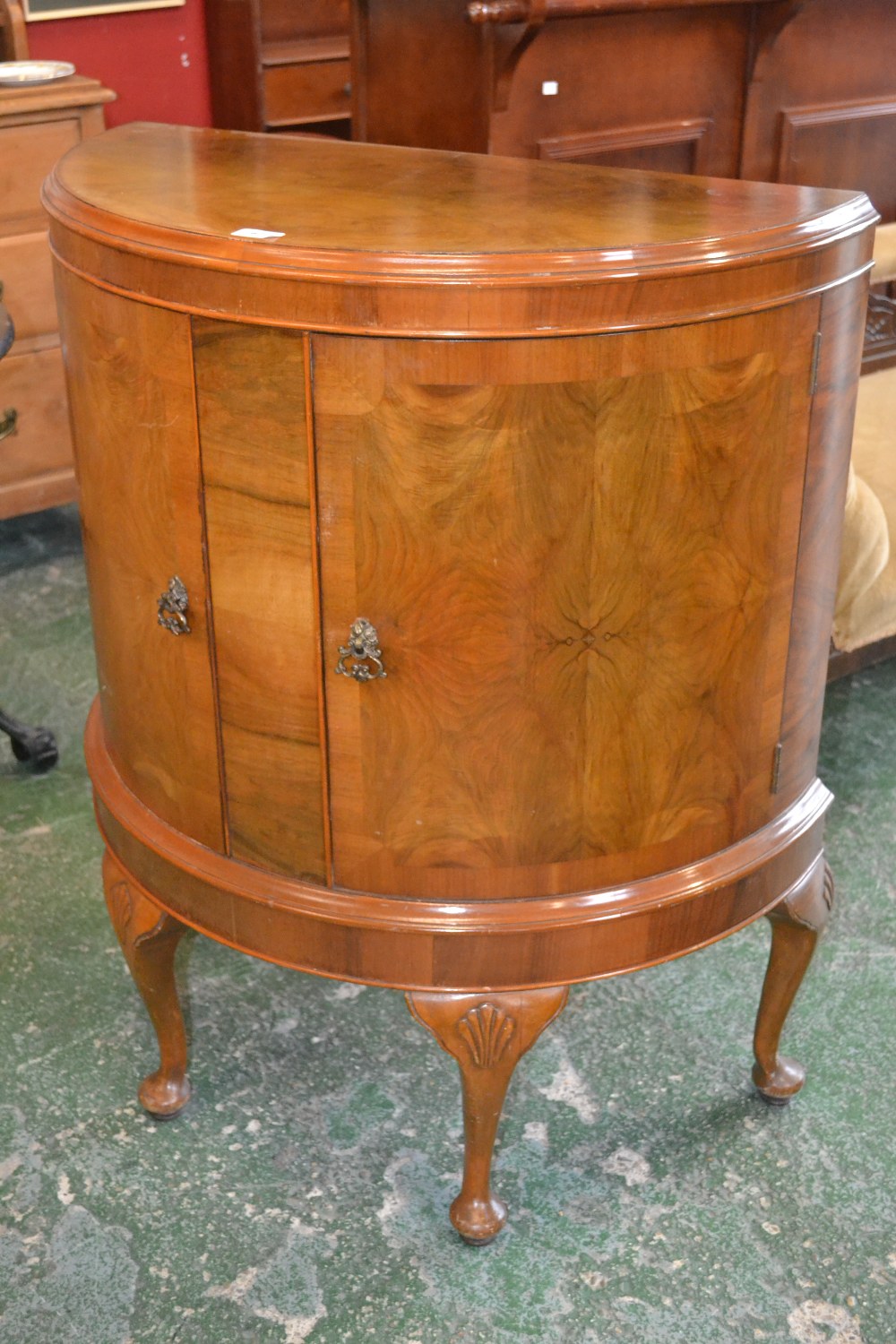 A reproduction mahogany half moon shaped drinks cabinet