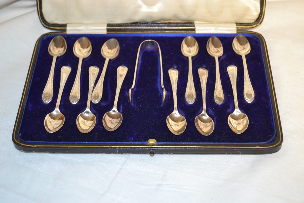 A set of twelve hall marked silver teaspoons and tongs